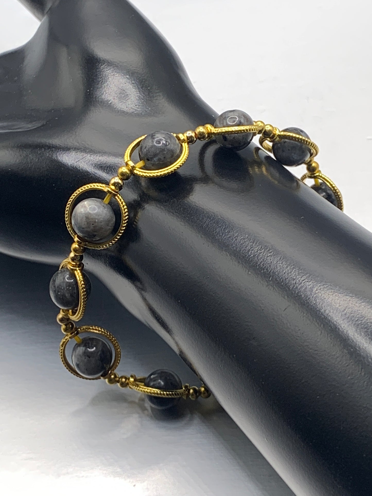 Larvikite semi precious stone/crystal elastic beaded bracelet with gold colored rings