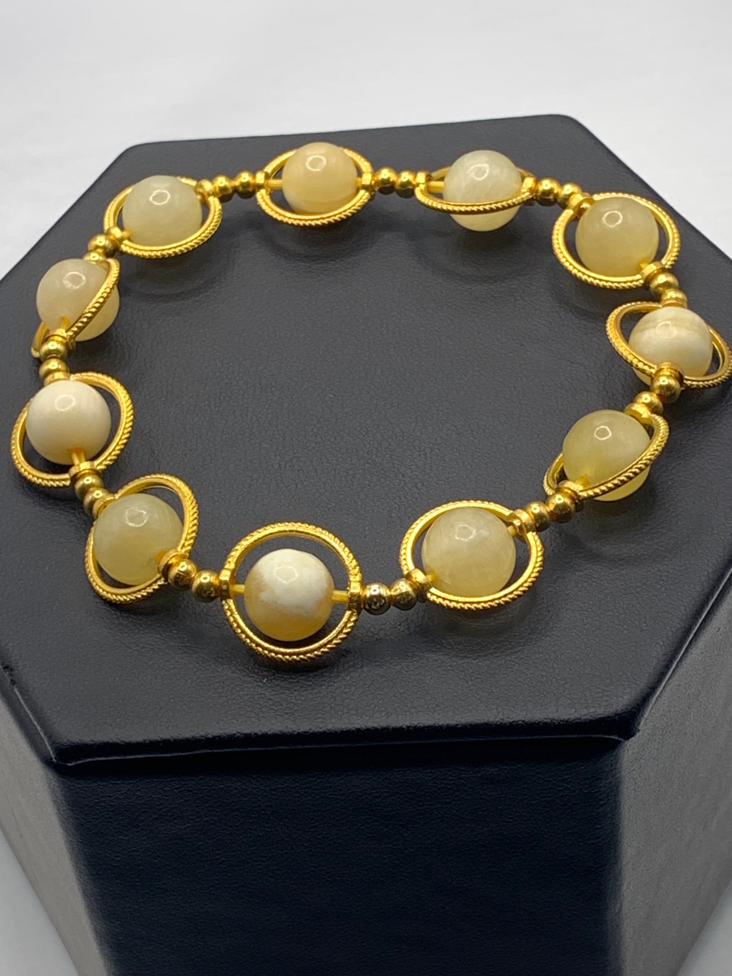 Yellow calcite semi precious stone/crystal elastic beaded bracelet with gold colored rings