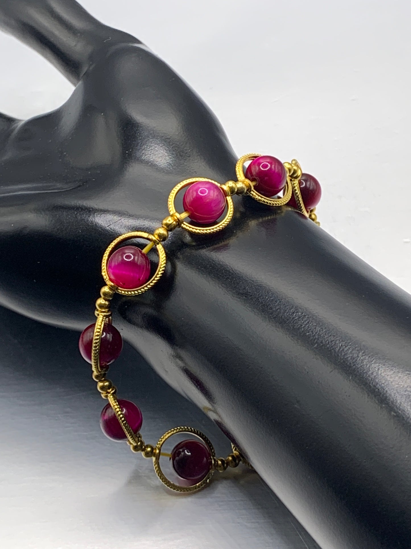 Pink tigers eye semi precious stone/crystal elastic beaded bracelet with gold colored rings