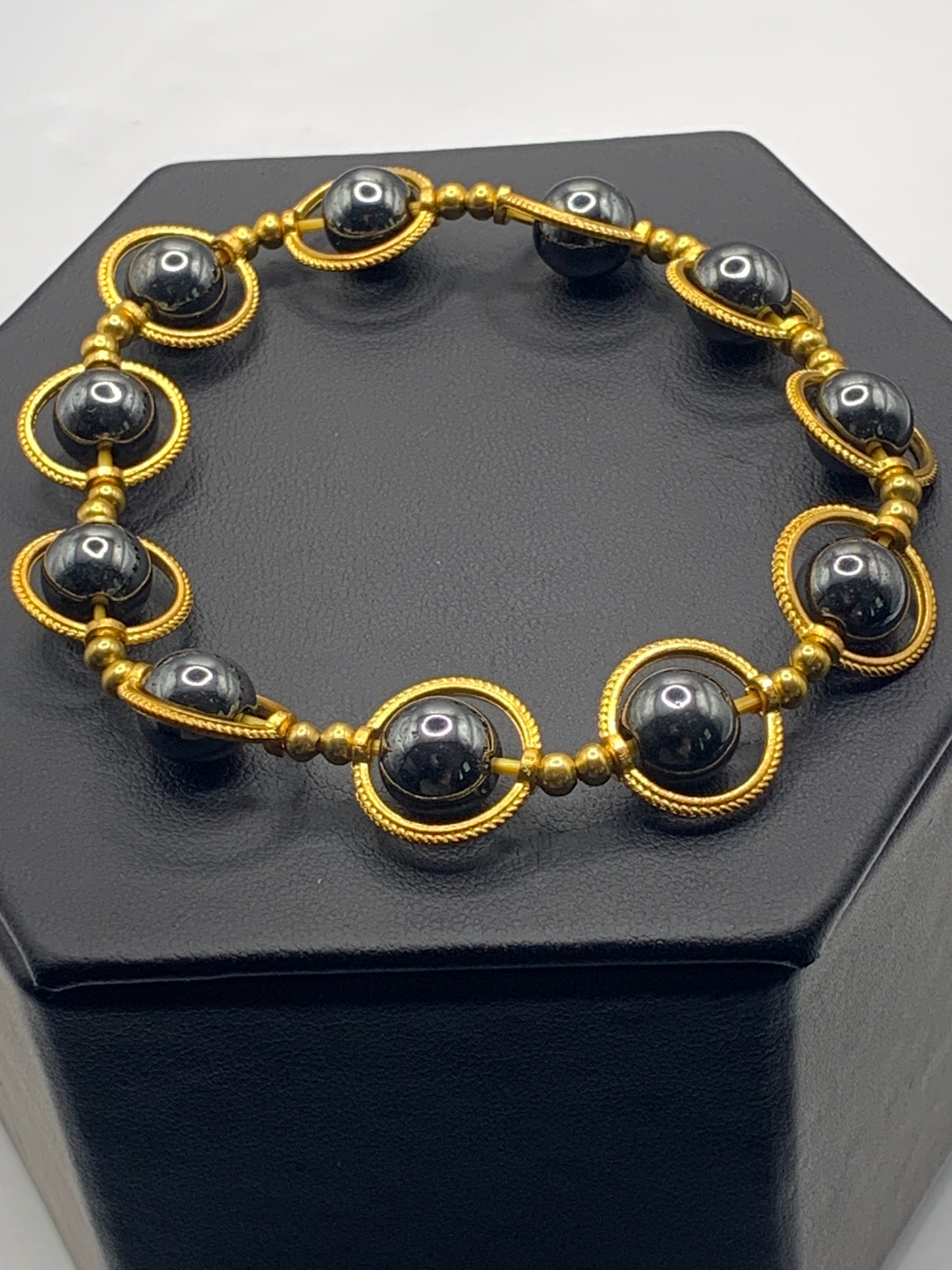 Hematite semi precious stone/crystal elastic beaded bracelet with gold colored rings