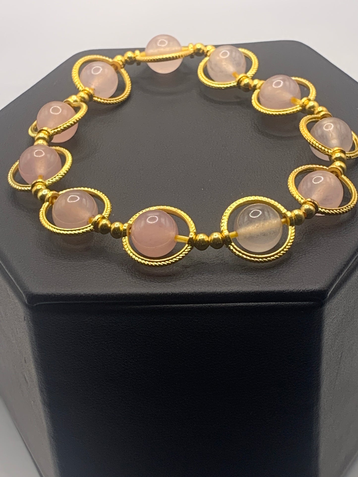 Rose quartz semi precious stone/crystal elastic beaded bracelet with gold colored rings
