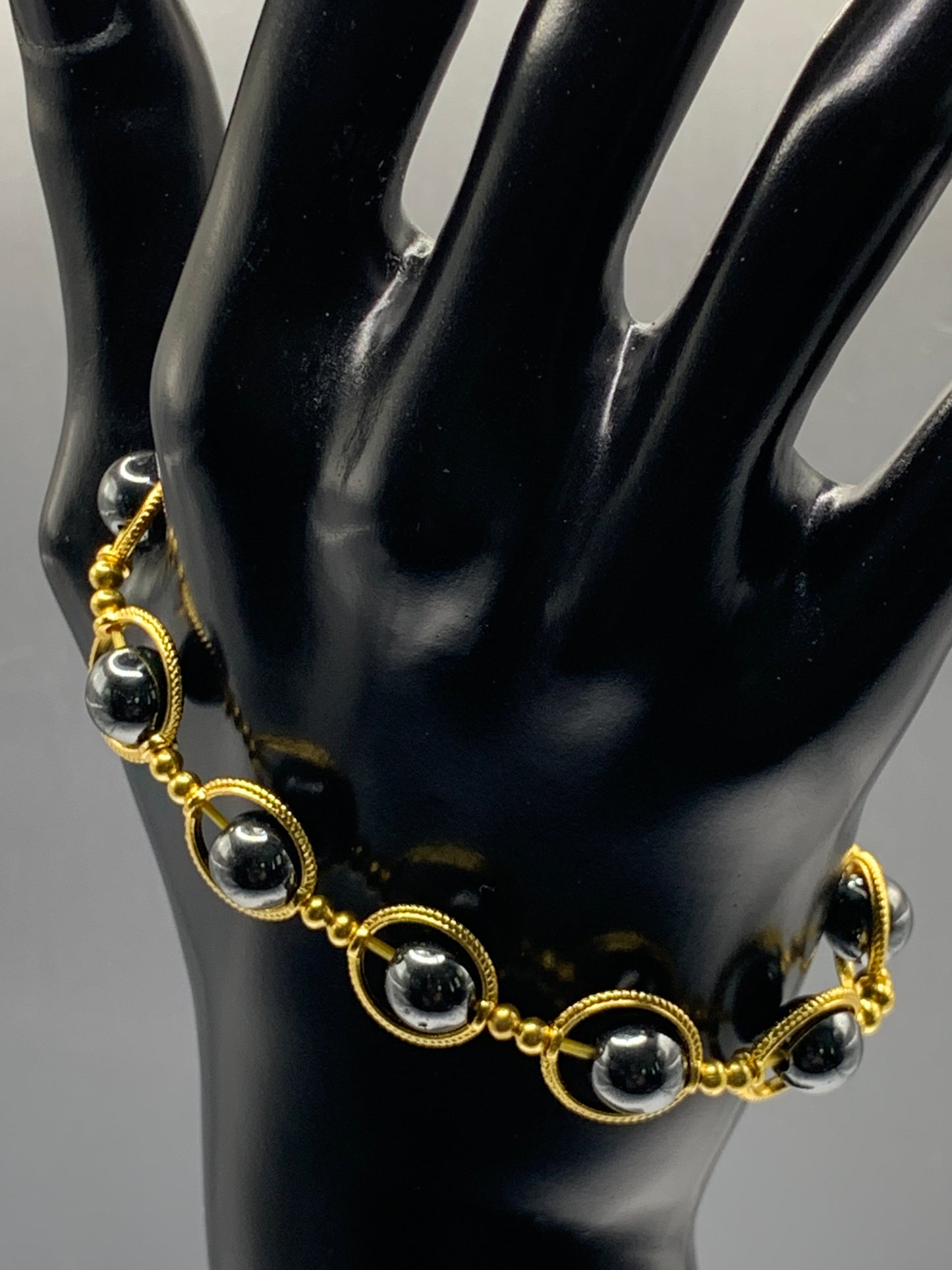 Hematite semi precious stone/crystal elastic beaded bracelet with gold colored rings