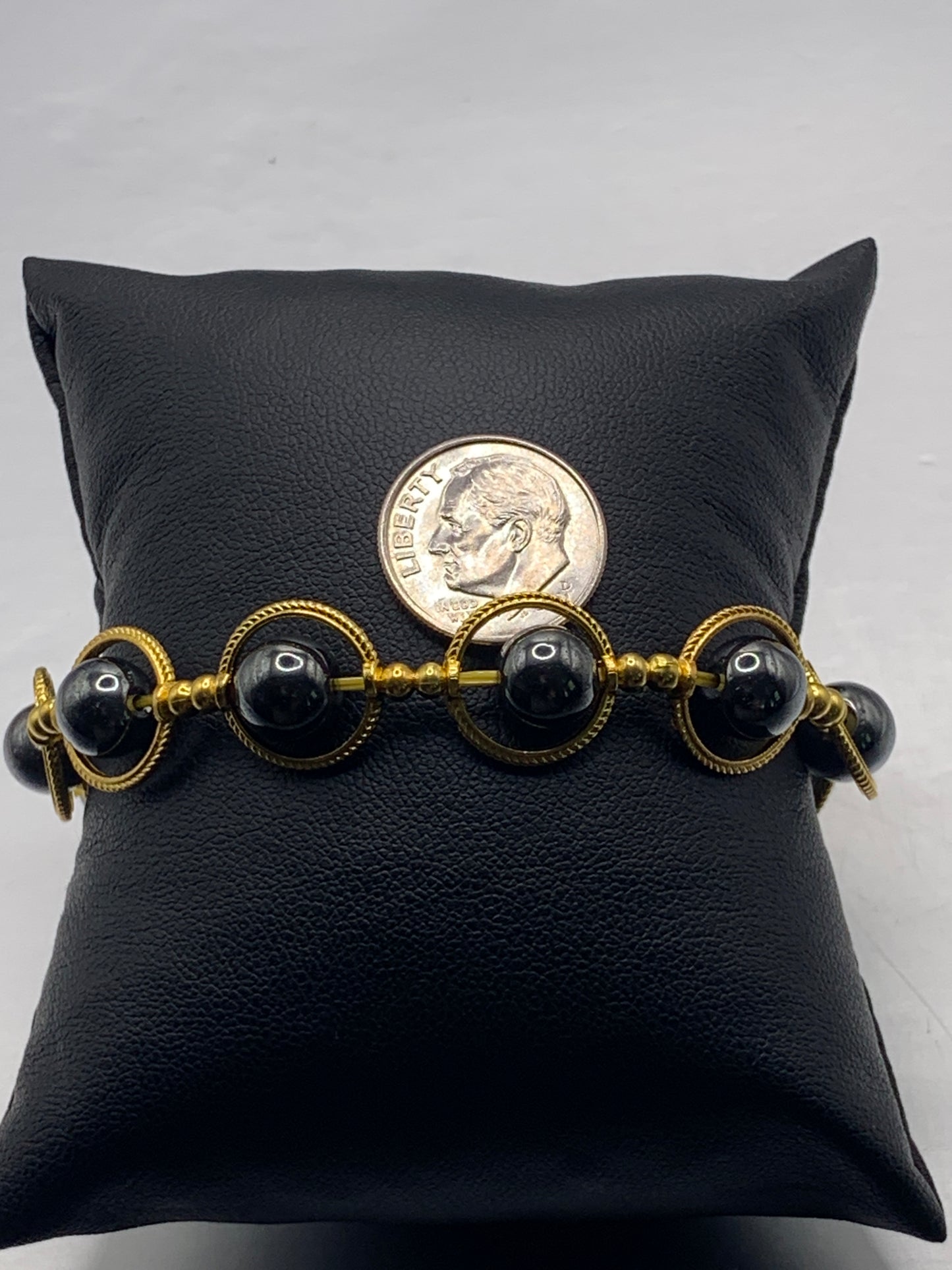Hematite semi precious stone/crystal elastic beaded bracelet with gold colored rings