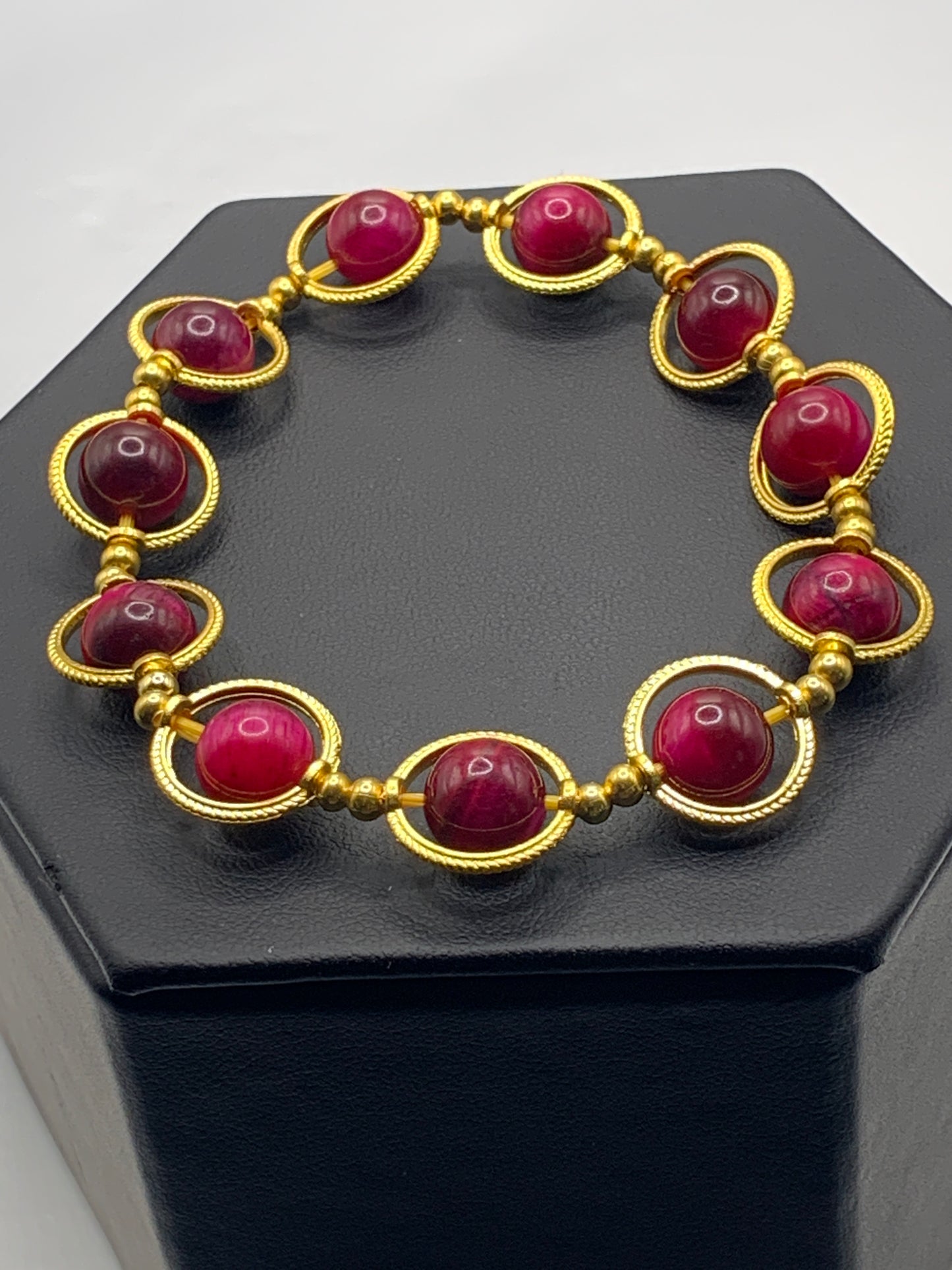 Pink tigers eye semi precious stone/crystal elastic beaded bracelet with gold colored rings