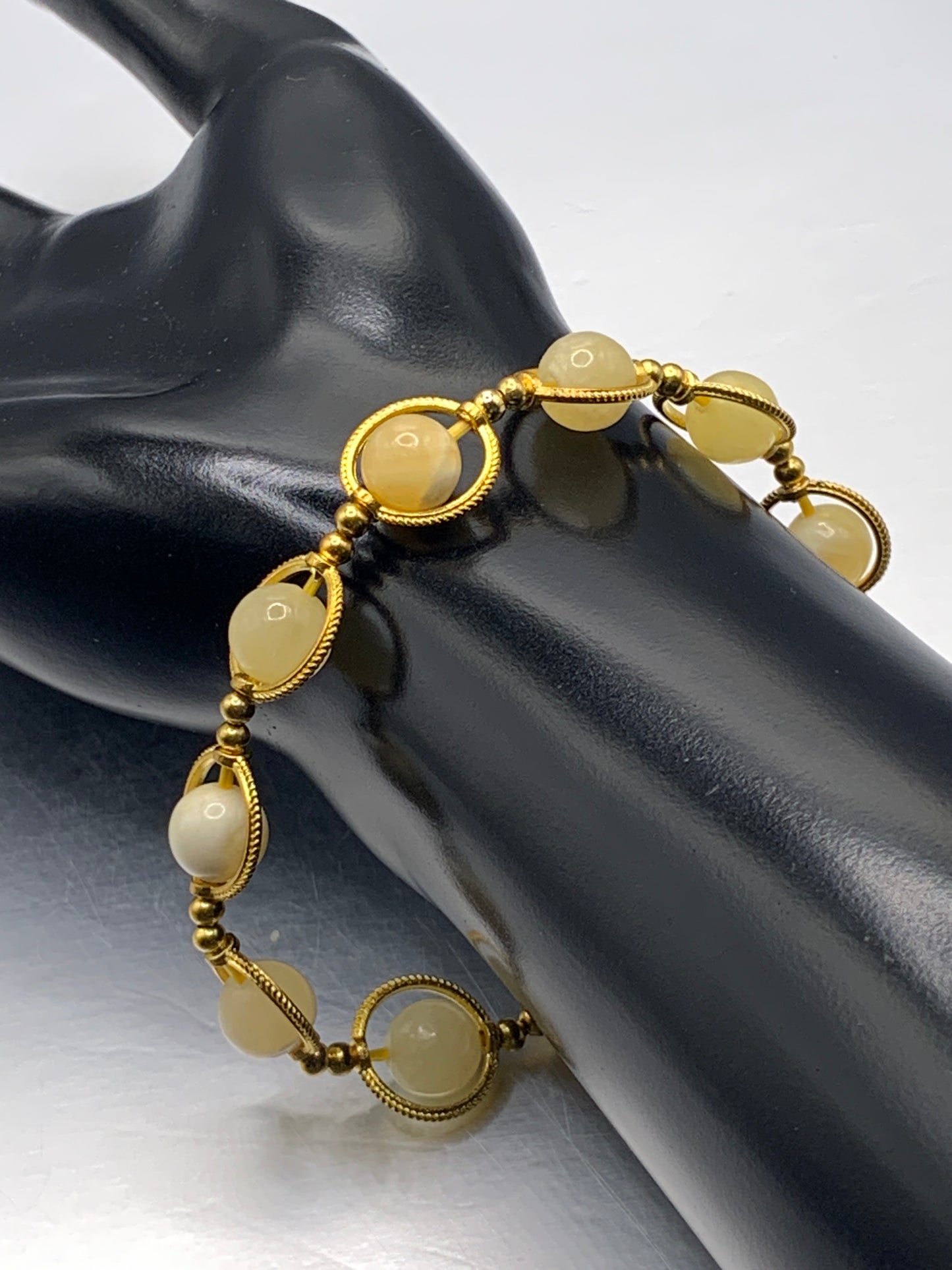 Yellow calcite semi precious stone/crystal elastic beaded bracelet with gold colored rings