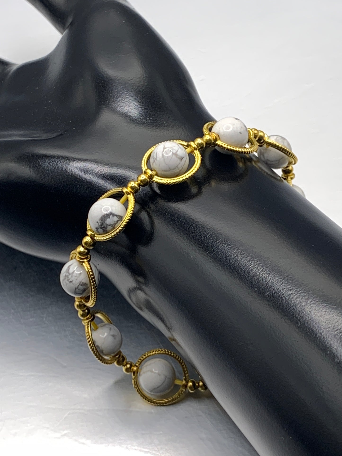 Howlite semi precious stone/crystal elastic beaded bracelet with gold colored rings