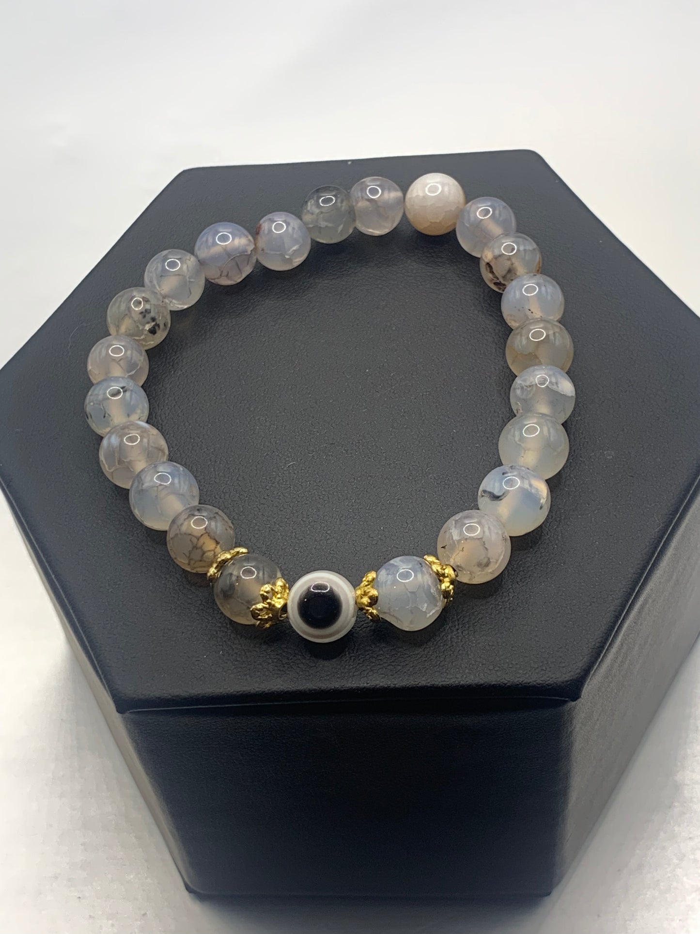 This bracelet features dragon vein agate beads and a colorful evil eye resin bead with gold flower caps. These are 8mm beads, made with elastic string to stretch onto the wrist and is approximately 17 cm or 6.7 inches
These are natural semi-precious stones/crystals. Even if they are dyed, the base material is still natural and imperfections are common making them unique