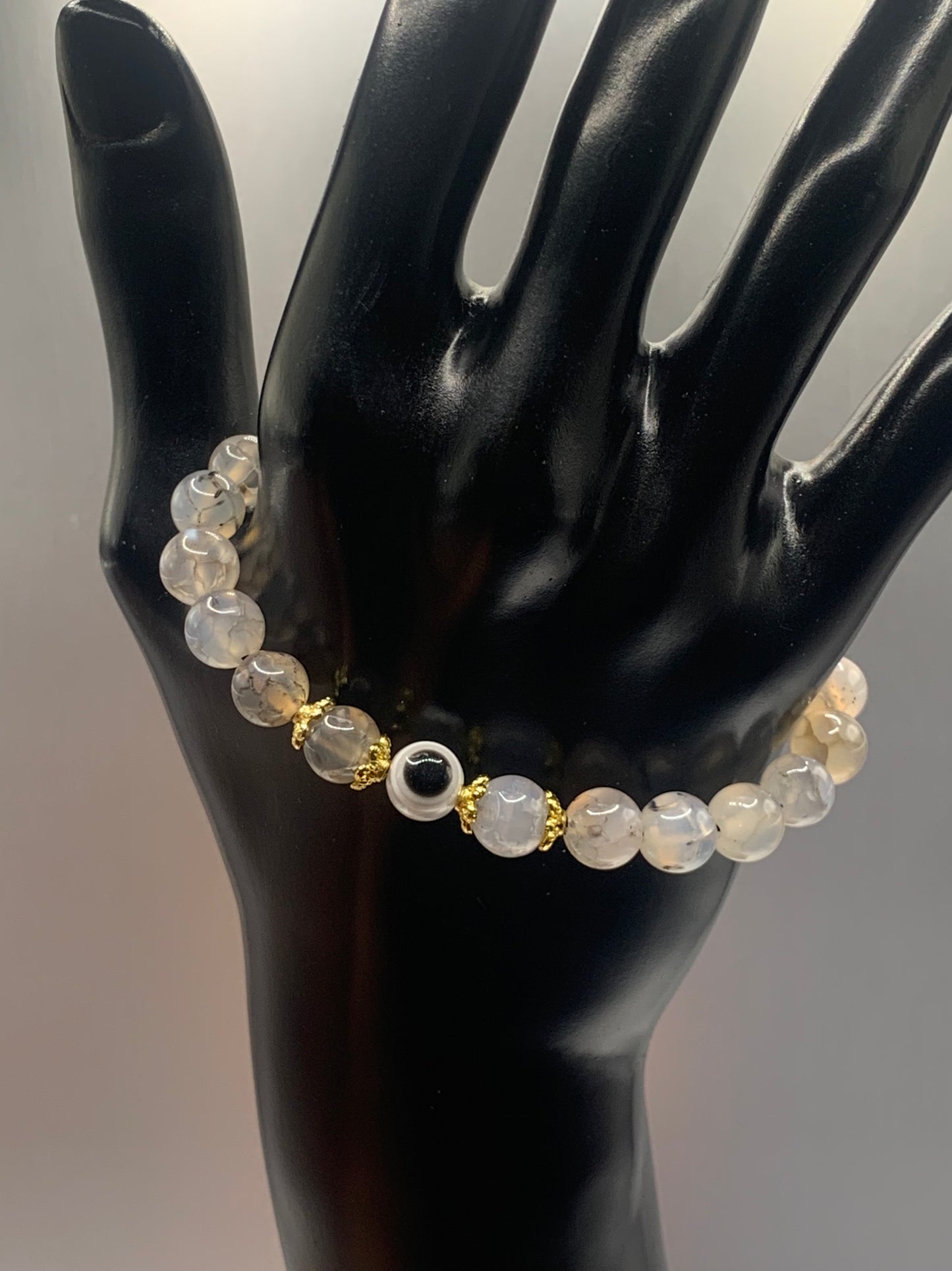 This bracelet features dragon vein agate beads and a colorful evil eye resin bead with gold flower caps. These are 8mm beads, made with elastic string to stretch onto the wrist and is approximately 17 cm or 6.7 inches
These are natural semi-precious stones/crystals. Even if they are dyed, the base material is still natural and imperfections are common making them unique