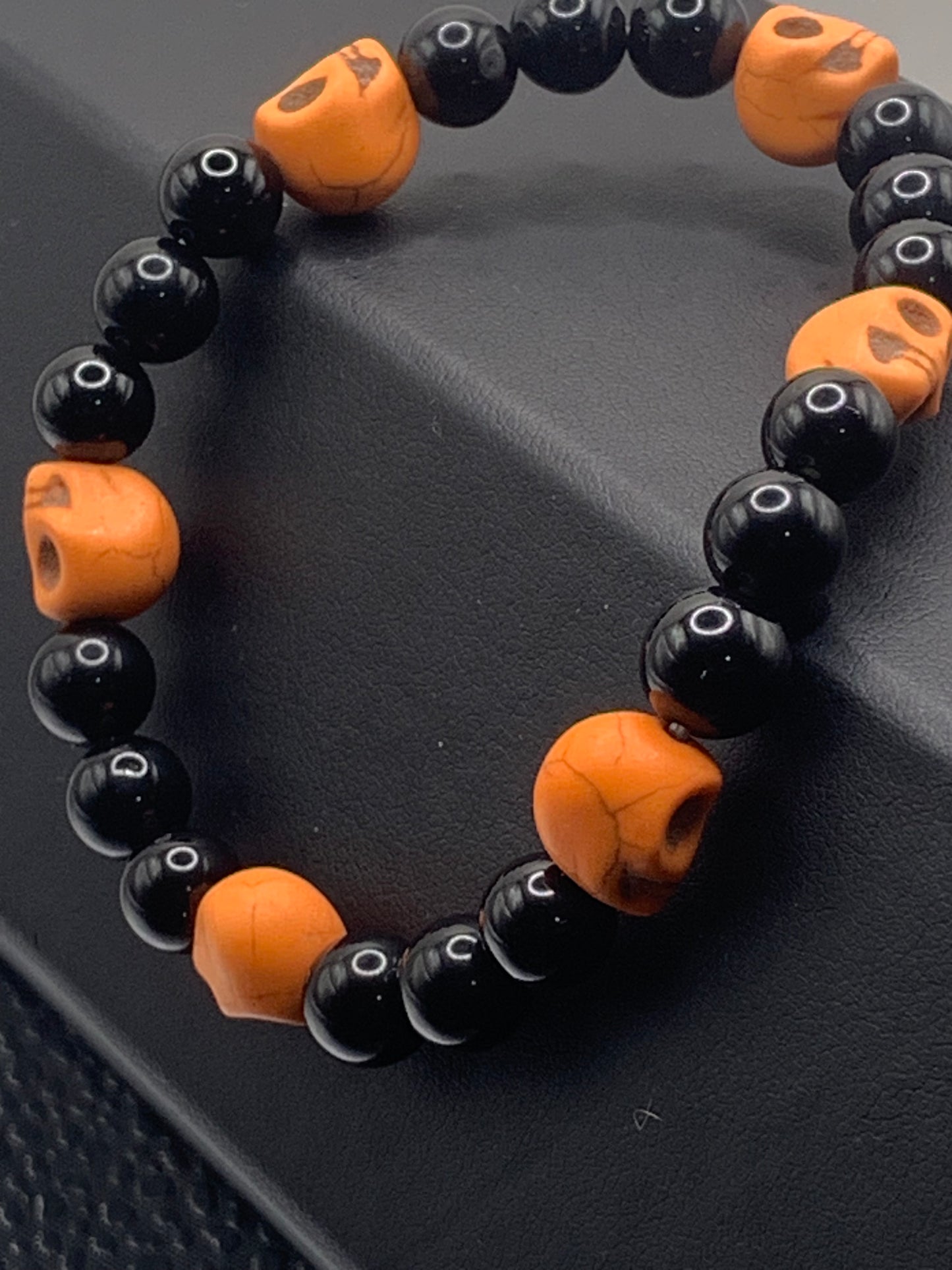 Black obsidian semi precious stone/crystal elastic beaded bracelet with orange resin skulls