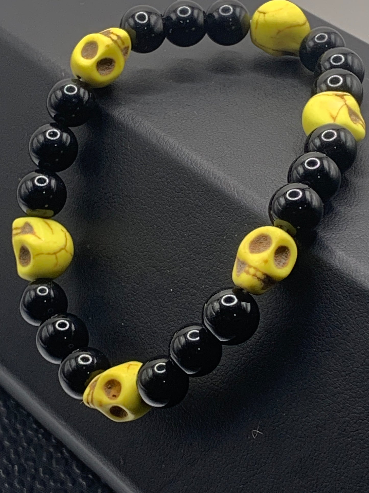 Black obsidian semi precious stone/crystal elastic beaded bracelet with yellow resin skulls
