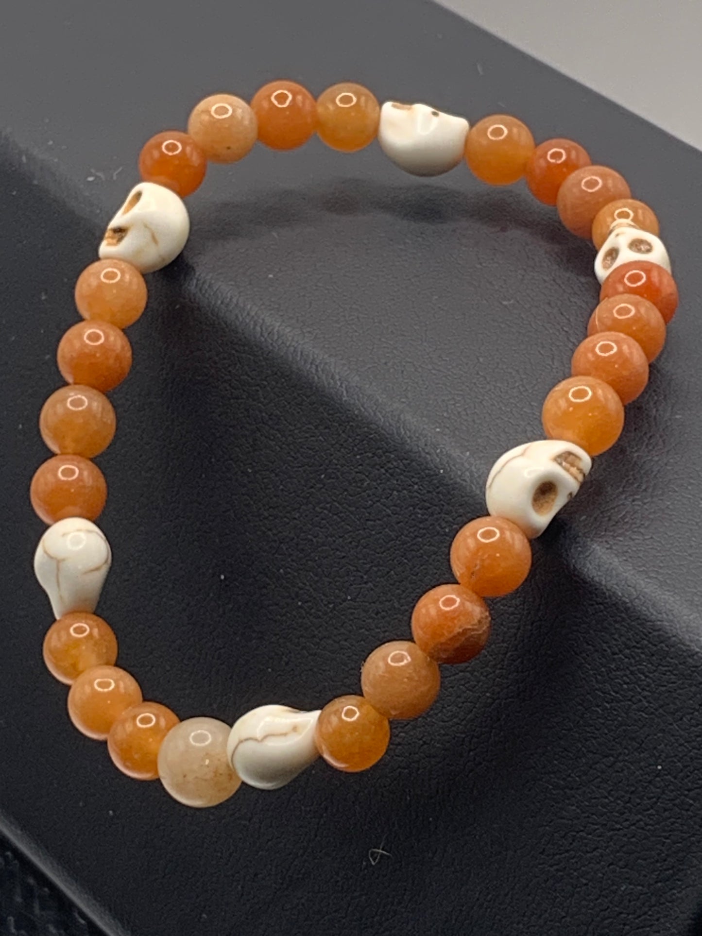Orange aventurine semi precious stone/crystal elastic beaded bracelet with white resin skulls