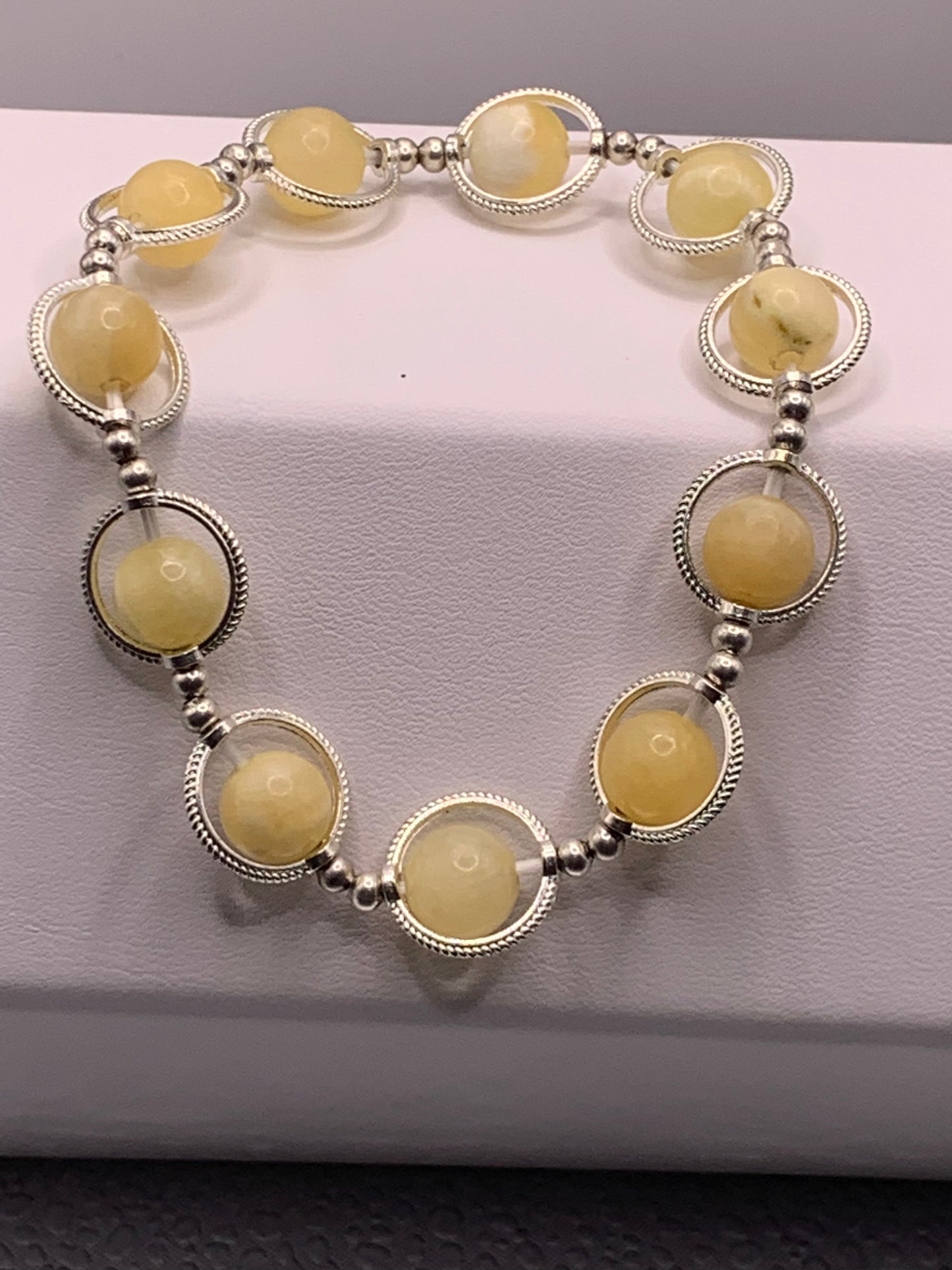 Yellow calcite semi precious stone/crystal elastic beaded bracelet with silver colored rings