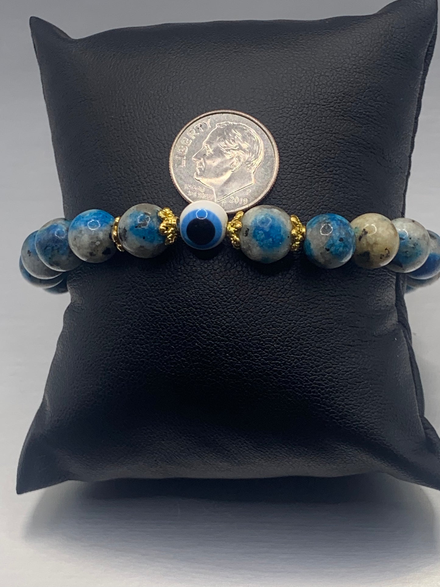This bracelet features k2 jasper beads and a colorful evil eye resin bead with gold flower caps. These are 8mm beads, made with elastic string to stretch onto the wrist and is approximately 17 cm or 6.7 inches
These are natural semi-precious stones/crystals. Even if they are dyed, the base material is still natural and imperfections are common making them unique.