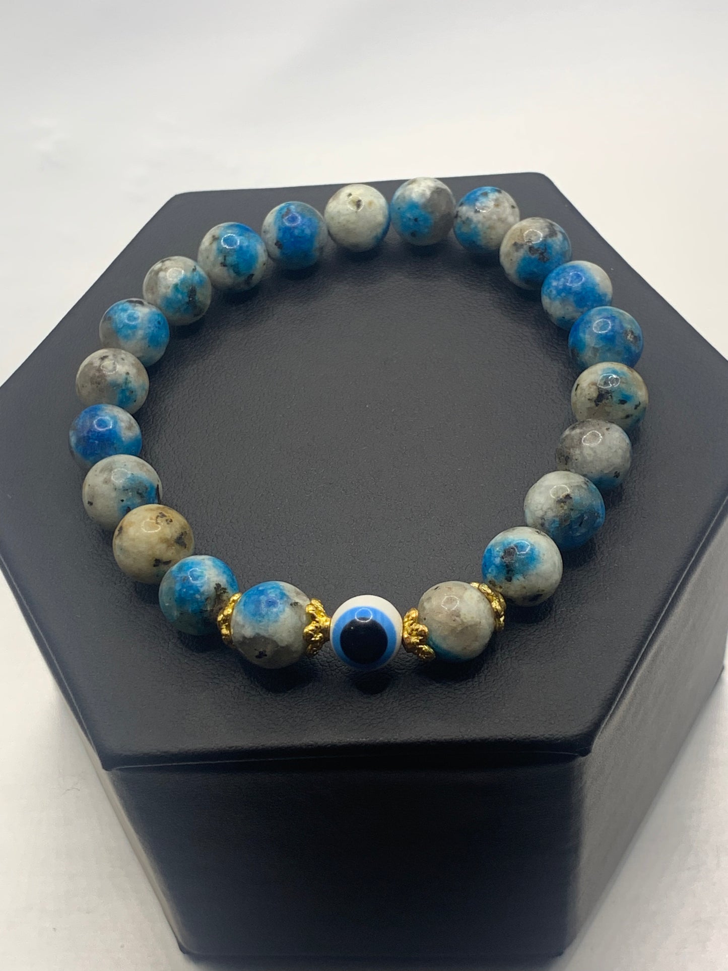 This bracelet features k2 jasper beads and a colorful evil eye resin bead with gold flower caps. These are 8mm beads, made with elastic string to stretch onto the wrist and is approximately 17 cm or 6.7 inches
These are natural semi-precious stones/crystals. Even if they are dyed, the base material is still natural and imperfections are common making them unique.