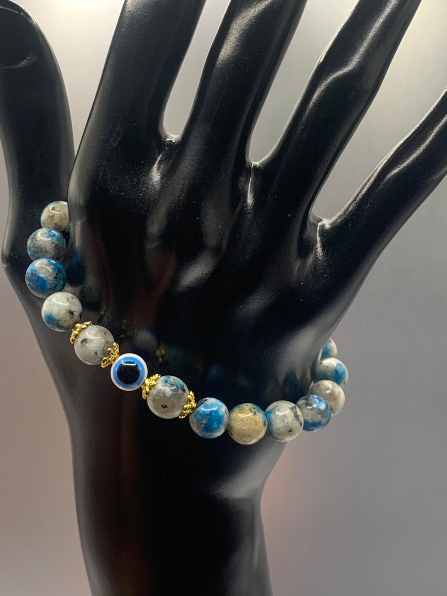 This bracelet features k2 jasper beads and a colorful evil eye resin bead with gold flower caps. These are 8mm beads, made with elastic string to stretch onto the wrist and is approximately 17 cm or 6.7 inches
These are natural semi-precious stones/crystals. Even if they are dyed, the base material is still natural and imperfections are common making them unique.