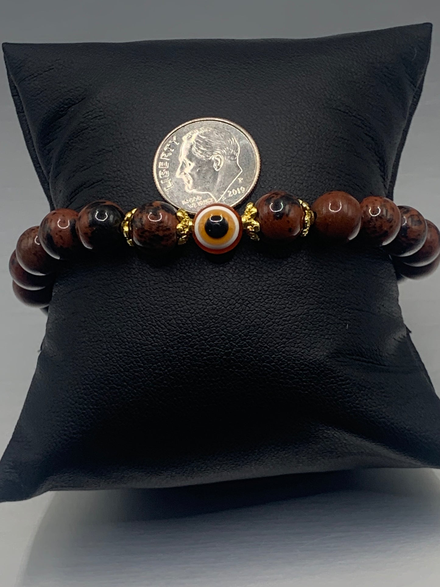 This bracelet features mahogany jasper beads and a colorful evil eye resin bead with gold flower caps. These are 8mm beads, made with elastic string to stretch onto the wrist and is approximately 17 cm or 6.7 inches
These are natural semi-precious stones/crystals. Even if they are dyed, the base material is still natural and imperfections are common making them unique