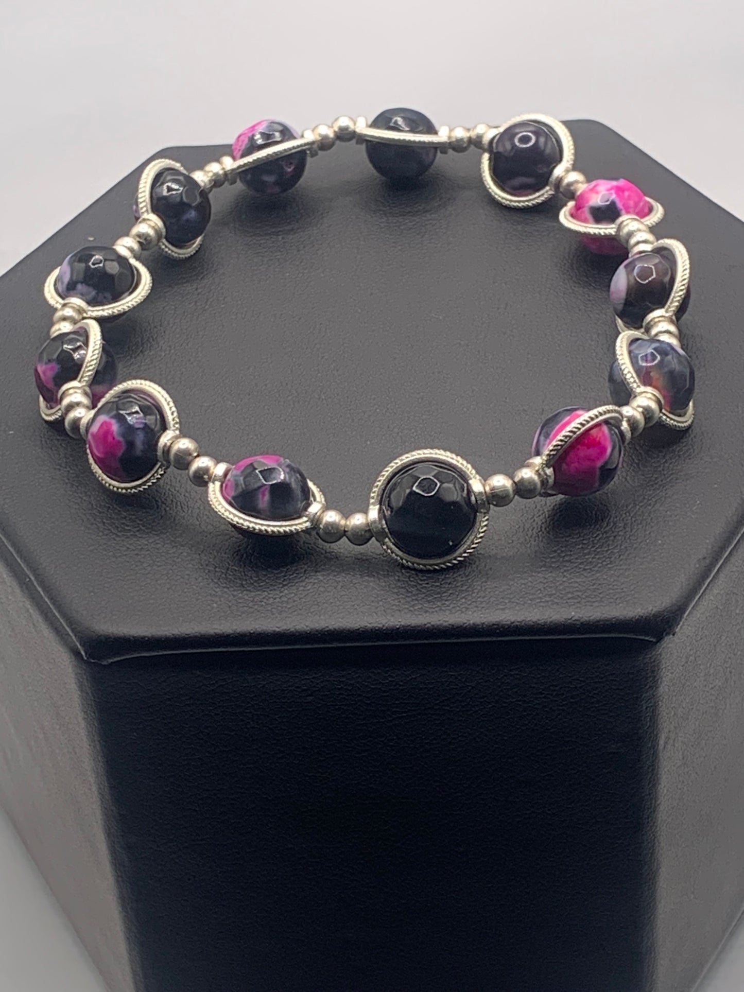 Bracelet with pink orca agate beads and silver accents on a black hexagonal box