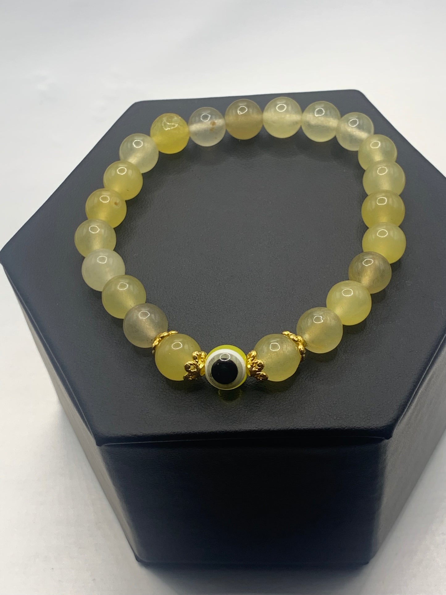 This bracelet features yellow agate beads and a colorful evil eye resin bead with gold flower caps. These are 8mm beads, made with elastic string to stretch onto the wrist and is approximately 17 cm or 6.7 inches.
These are natural semi-precious stones/crystals. Even if they are dyed, the base material is still natural and imperfections are common making them unique.