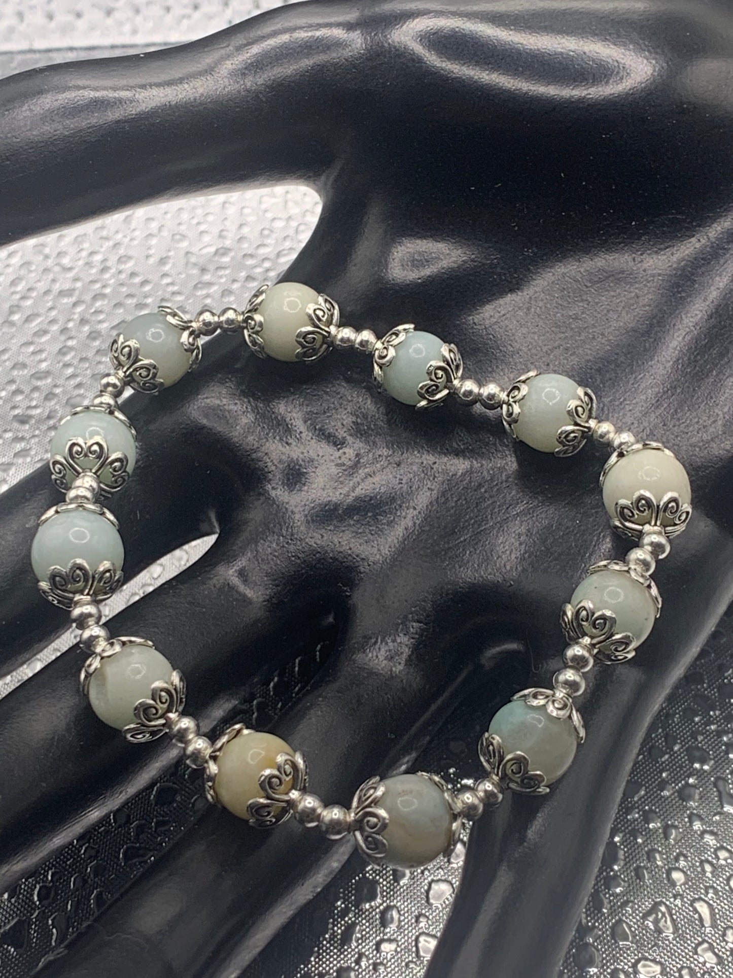 This bracelet contains amazonite beads that are surrounded by bead caps and spacer beads