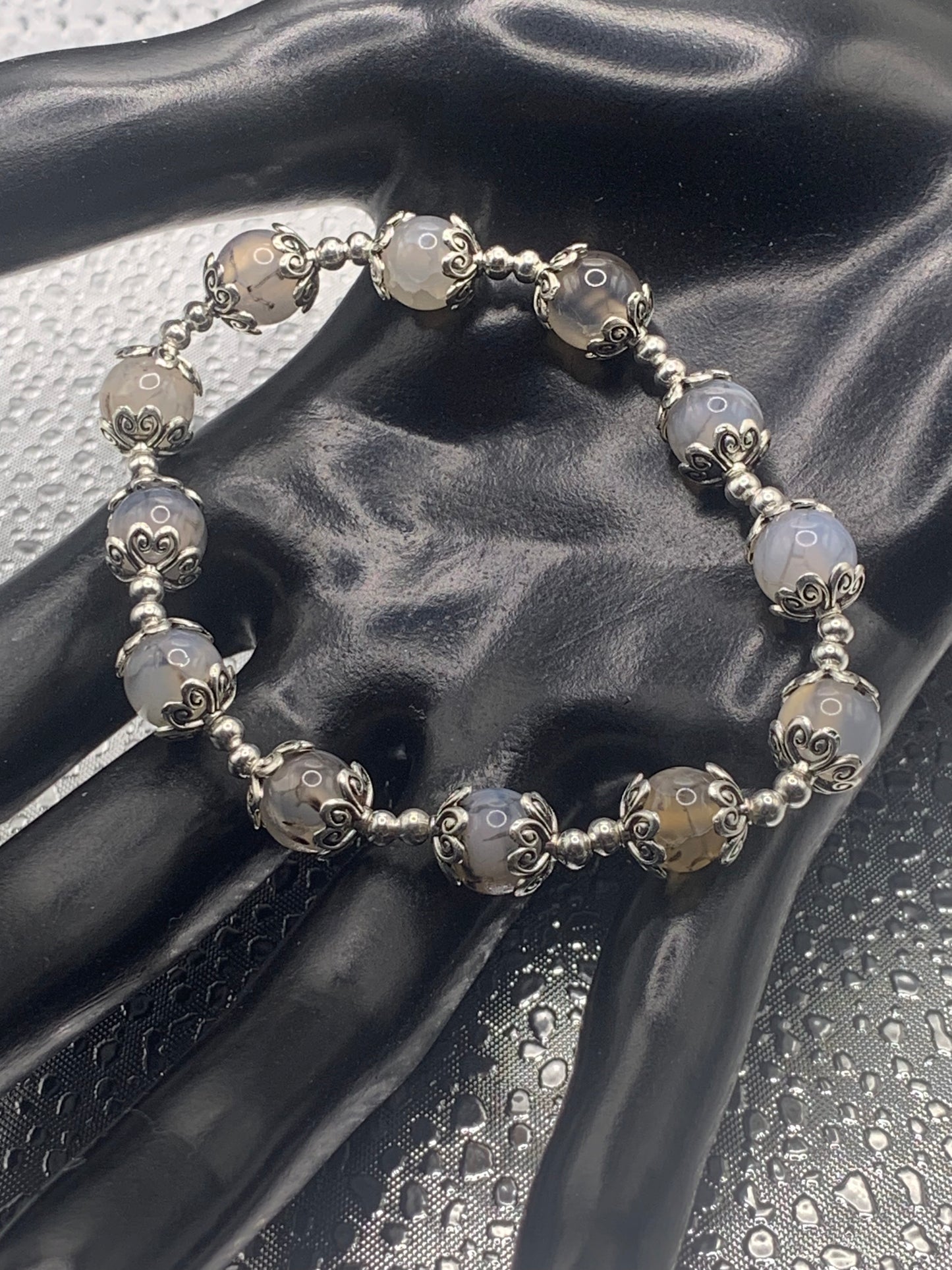 This bracelet contains dragon vein agate beads that are surrounded by bead caps and spacer beads