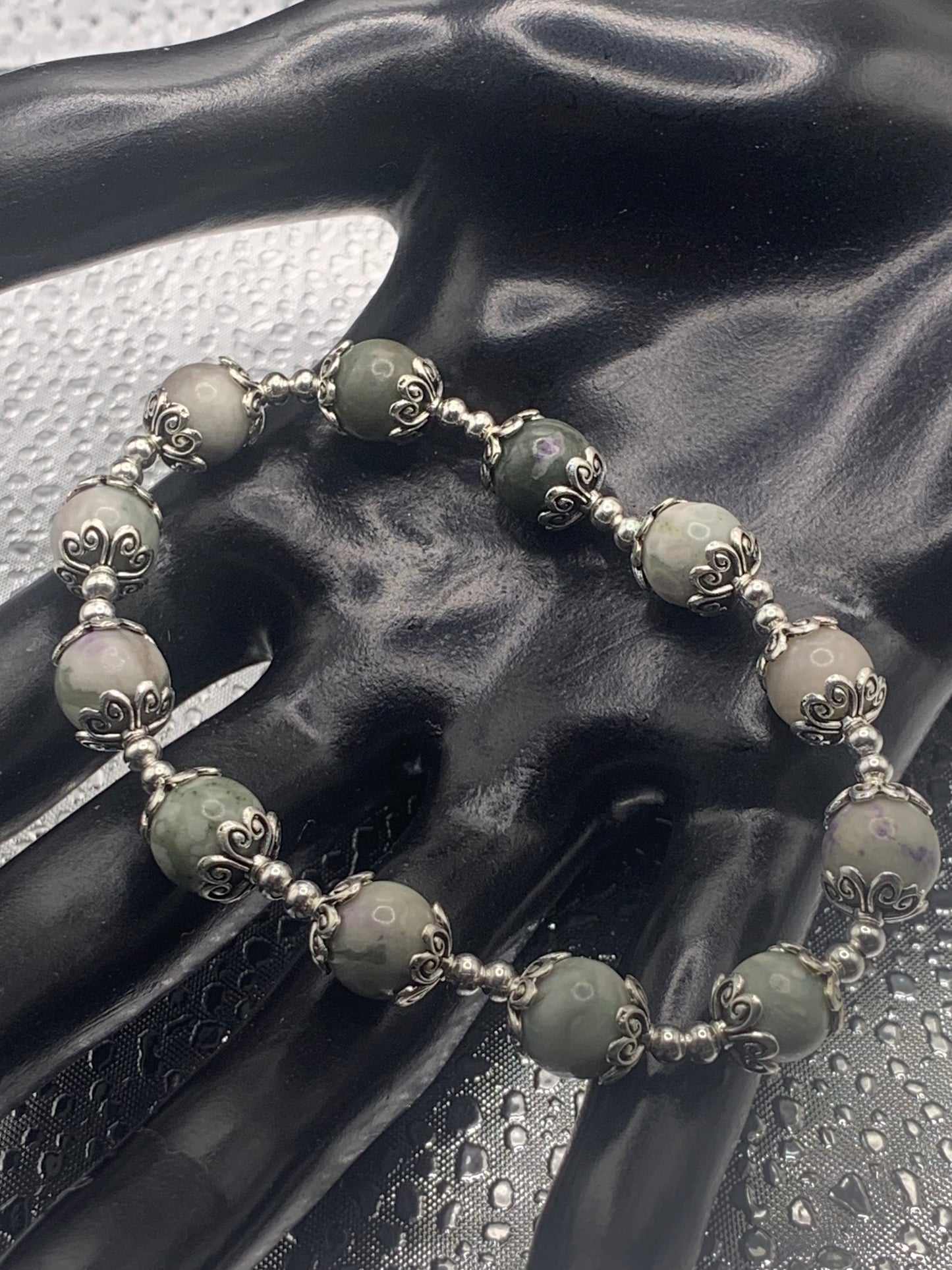 This bracelet contains lucky jade beads that are surrounded by bead caps and spacer beads