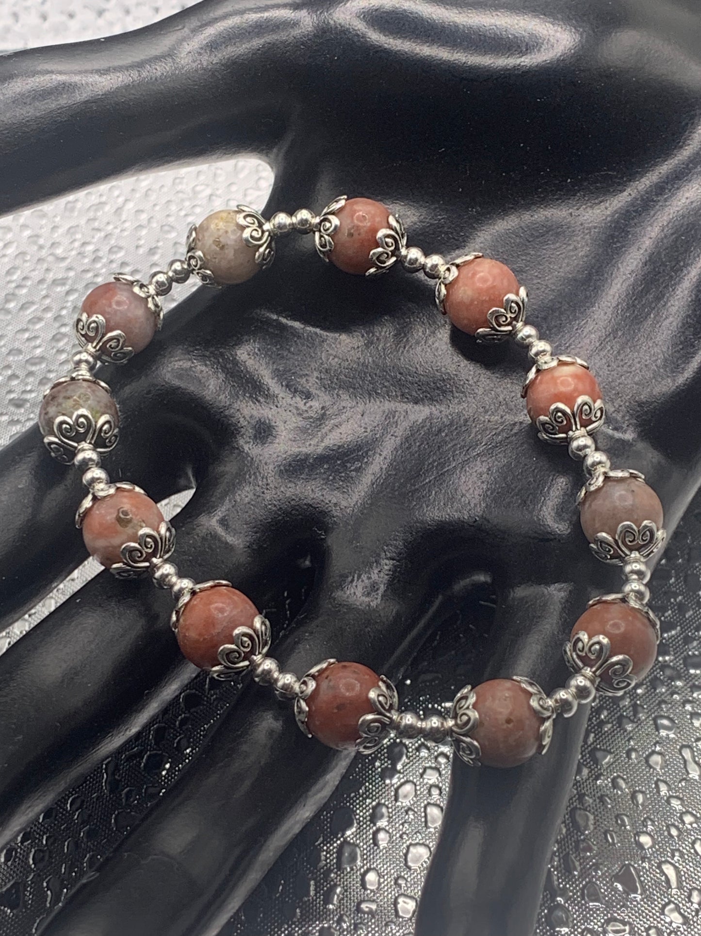 This bracelet contains pink lepidolite beads that are surrounded by bead caps and spacer beads