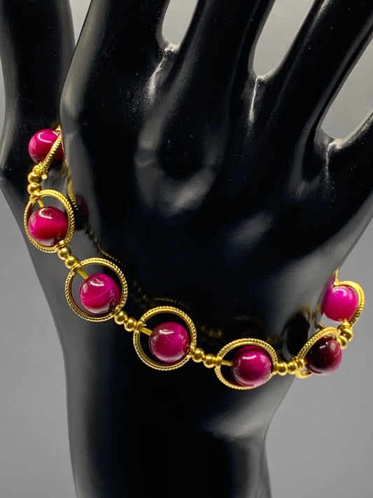 Pink tigers eye semi precious stone/crystal elastic beaded bracelet with gold colored rings