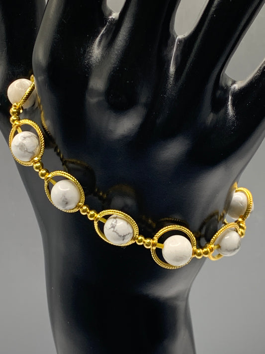 Howlite semi precious stone/crystal elastic beaded bracelet with gold colored rings