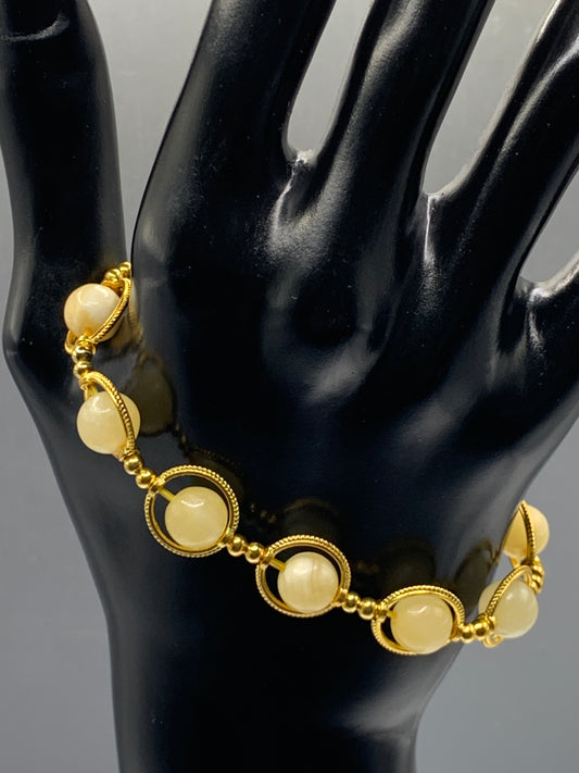 Yellow calcite semi precious stone/crystal elastic beaded bracelet with gold colored rings