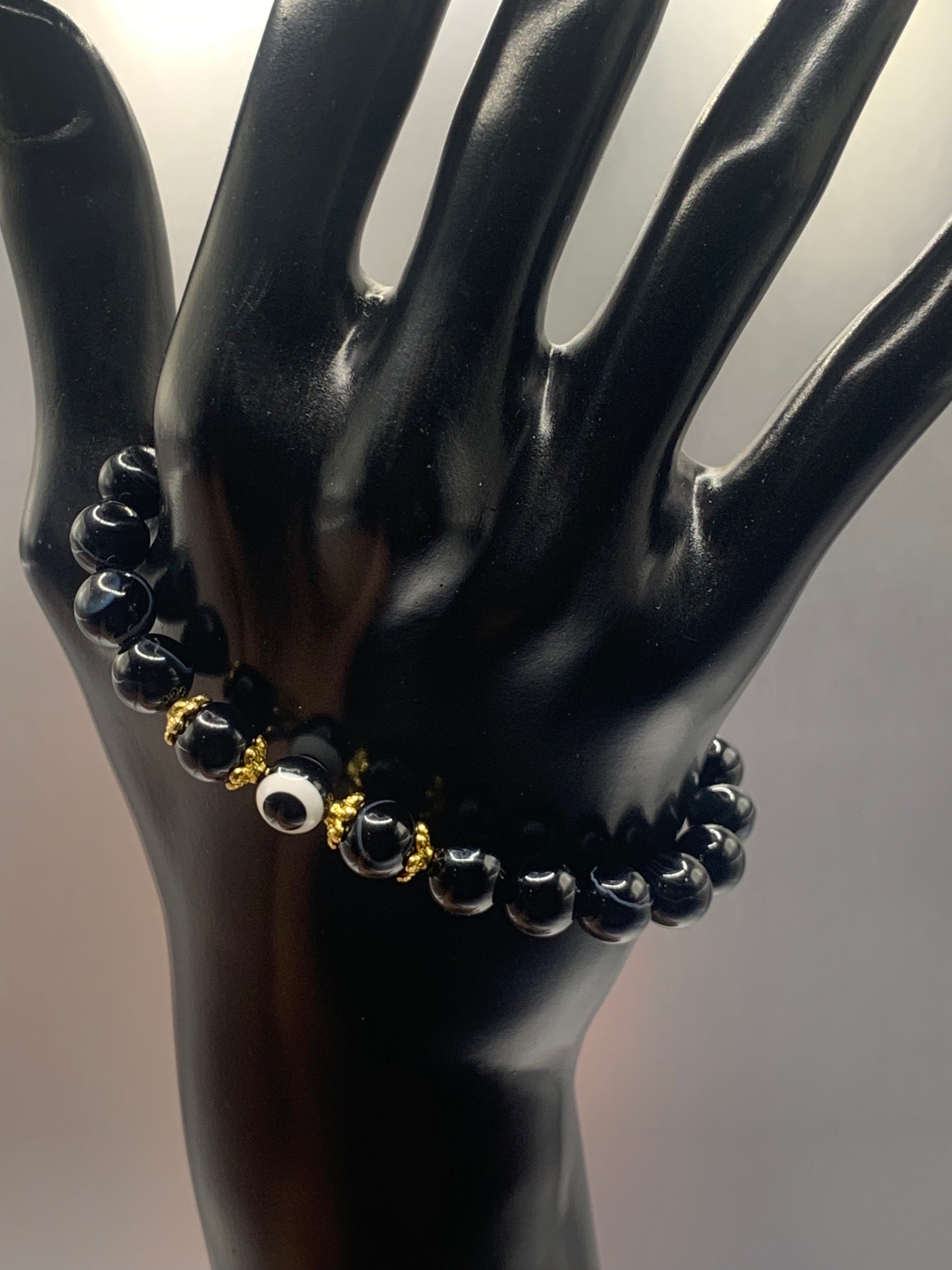 This bracelet features black lace agate beads and a colorful evil eye resin bead with gold flower caps. These are 8mm beads, made with elastic string to stretch onto the wrist and is approximately 17 cm or 6.7 inches



These are natural semi-precious stones/crystals. Even if they are dyed, the base material is still natural and imperfections are common making them unique