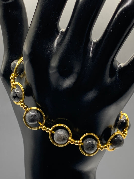 Larvikite semi precious stone/crystal elastic beaded bracelet with gold colored rings