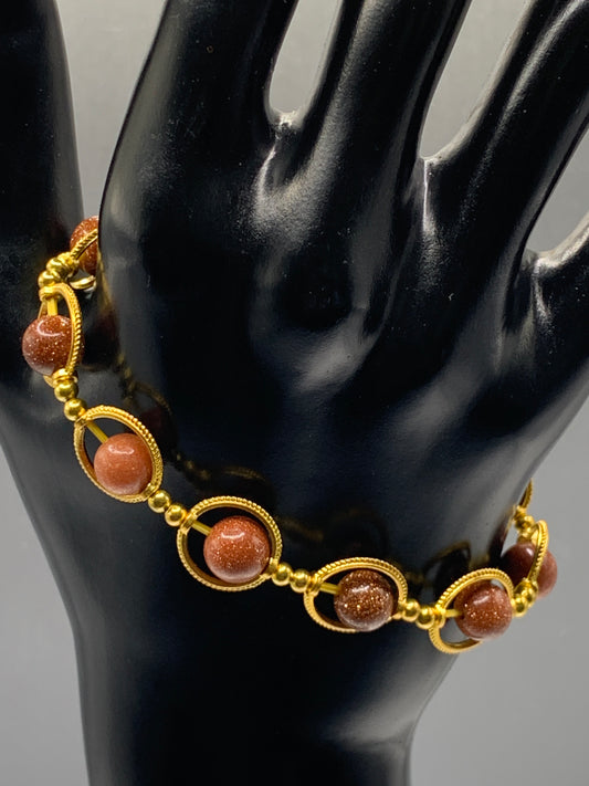 Sandstone semi precious stone/crystal elastic beaded bracelet with gold colored rings