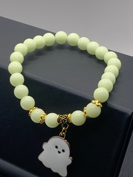 Yellow glow-in-the-dark elastic beaded bracelet with a Halloween charm