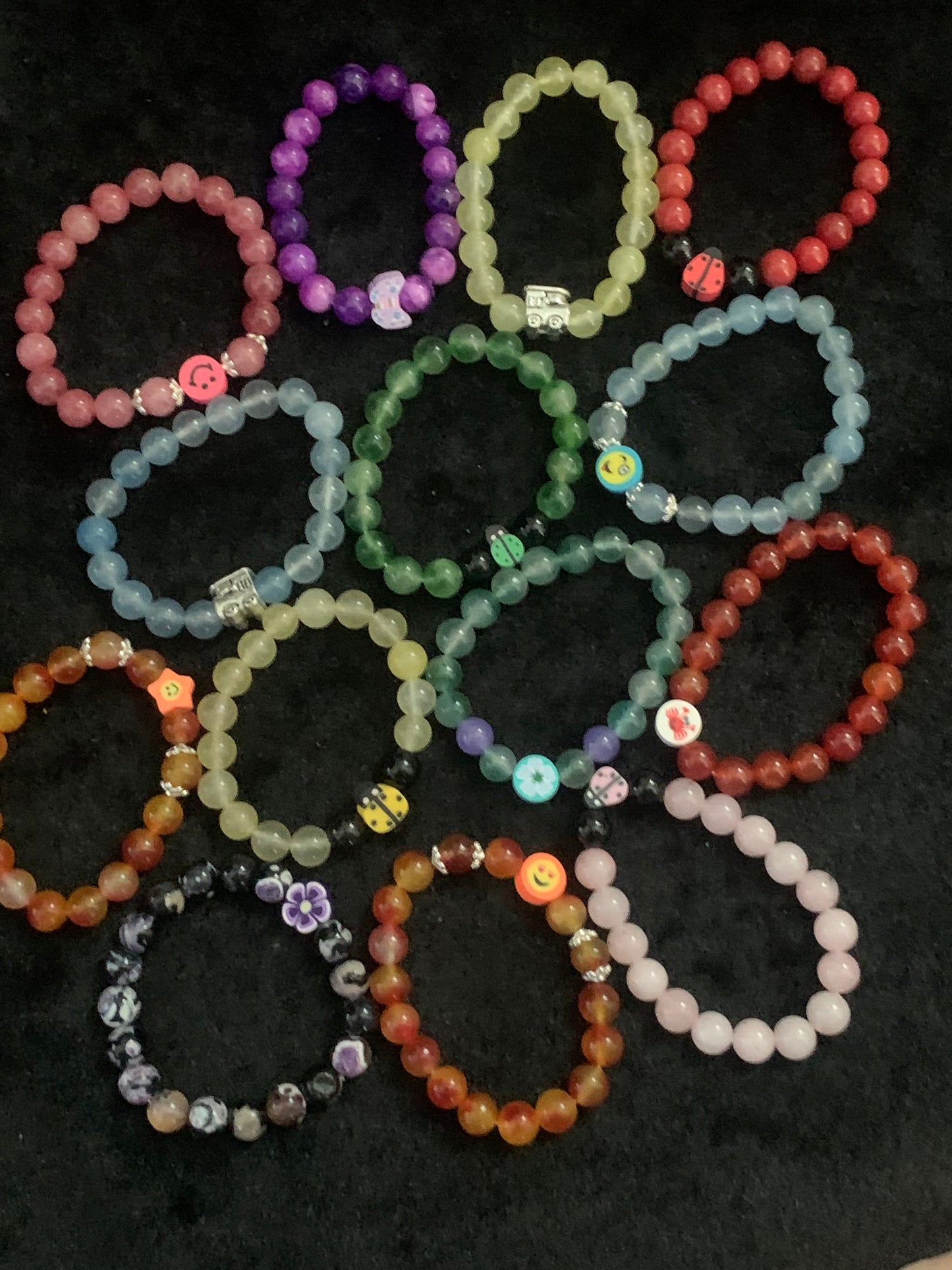 Collection of colorful beaded bracelets on a dark surface