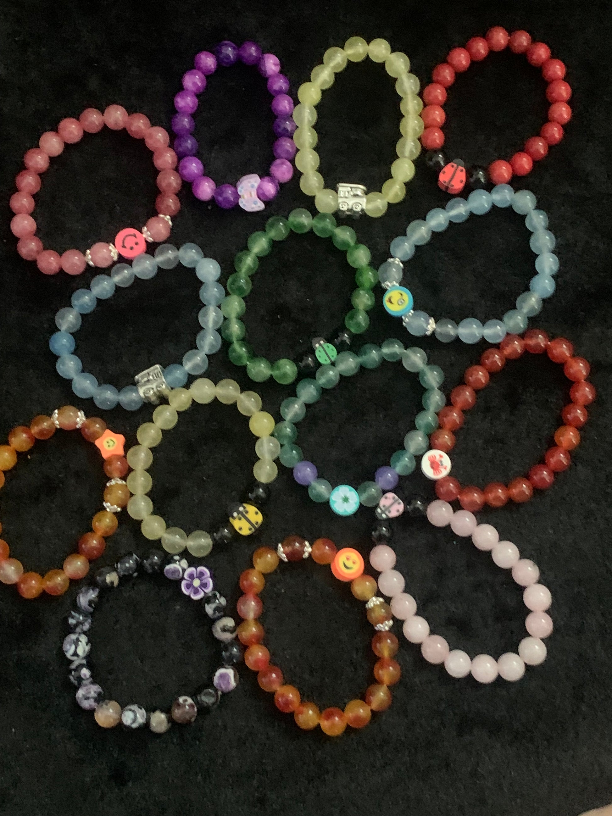 Collection of colorful beaded bracelets on a dark surface