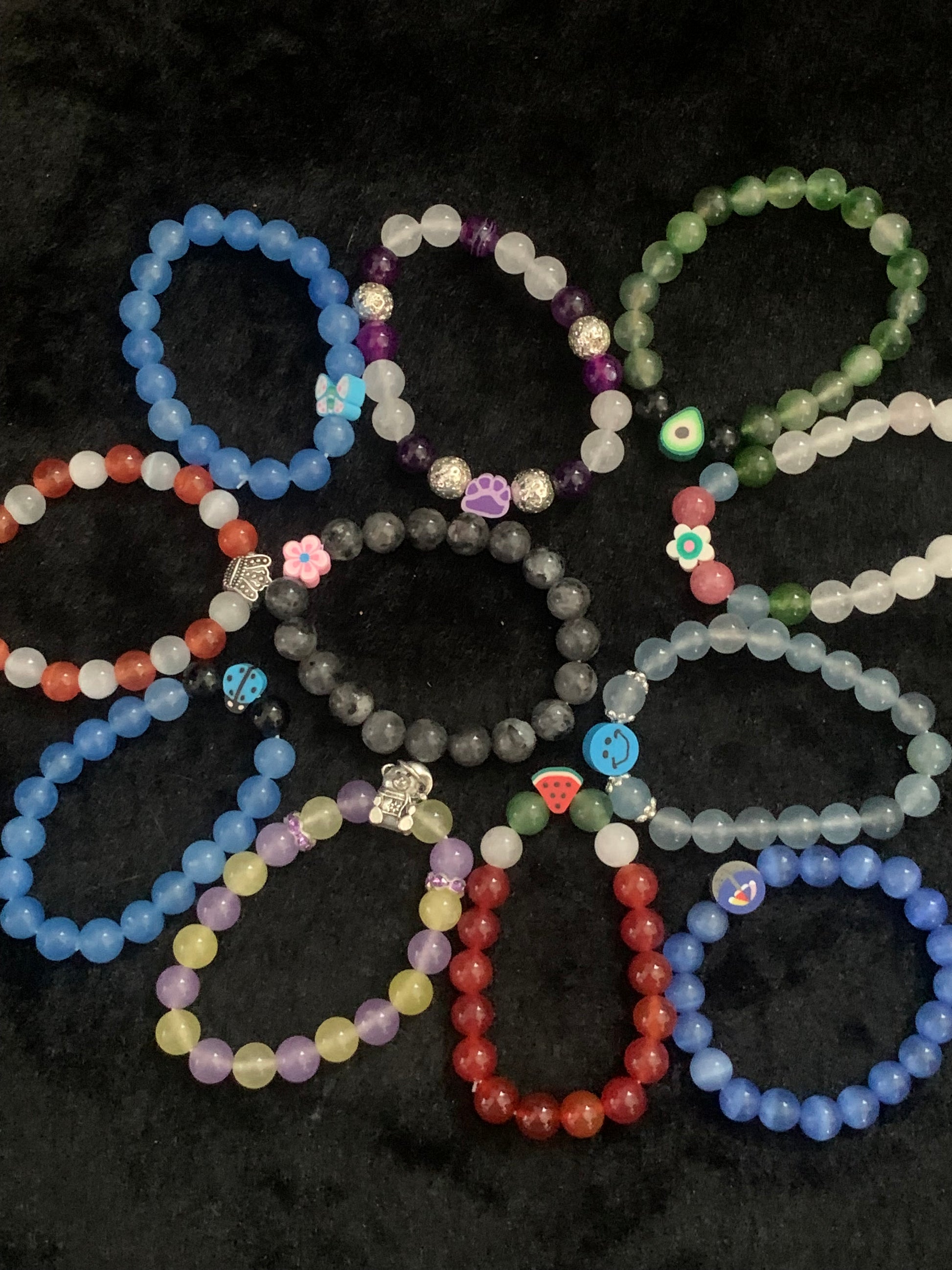 Colorful beaded bracelets on a dark textured surface