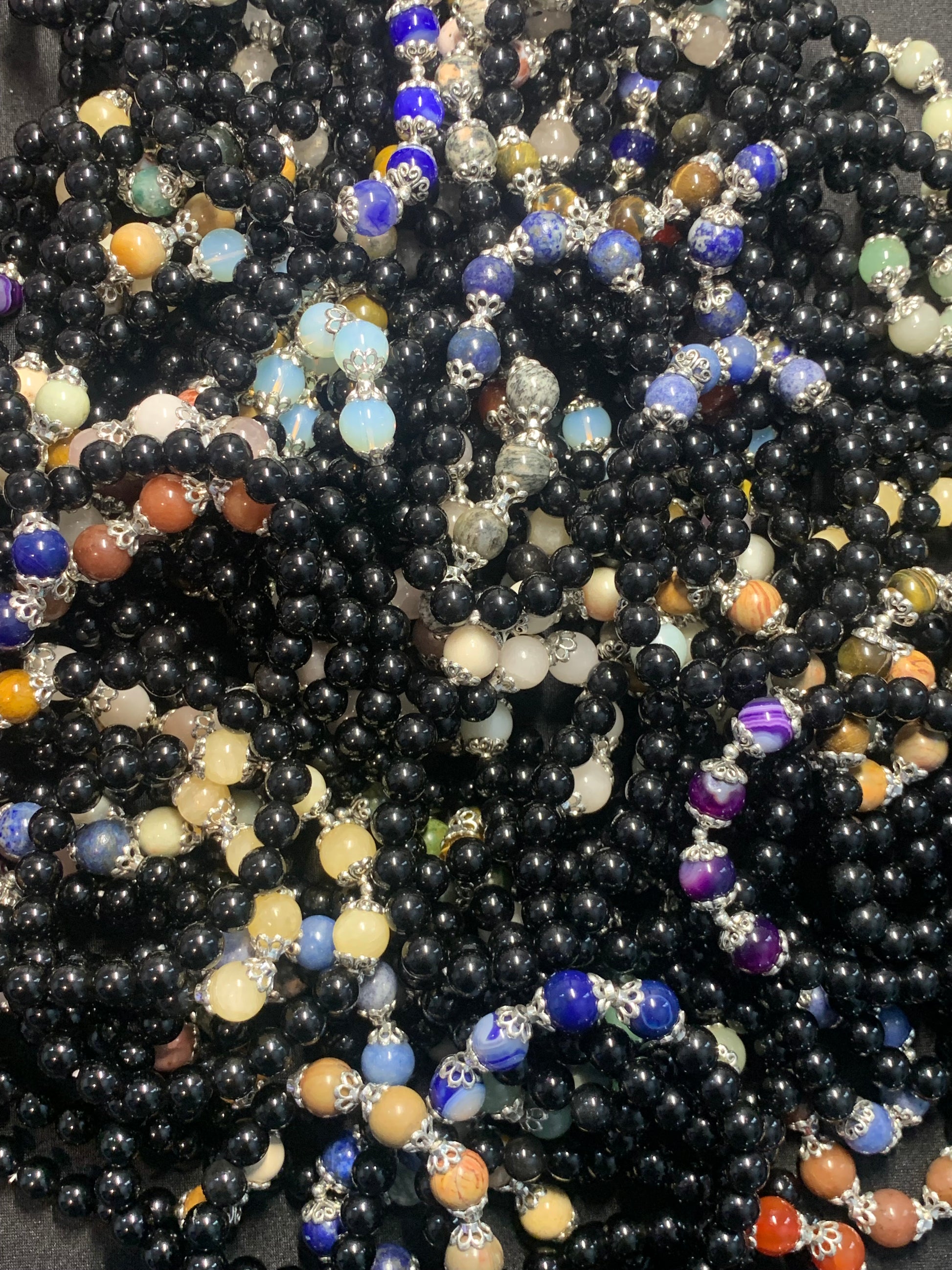 Close-up of a pile of multicolored beaded necklaces.