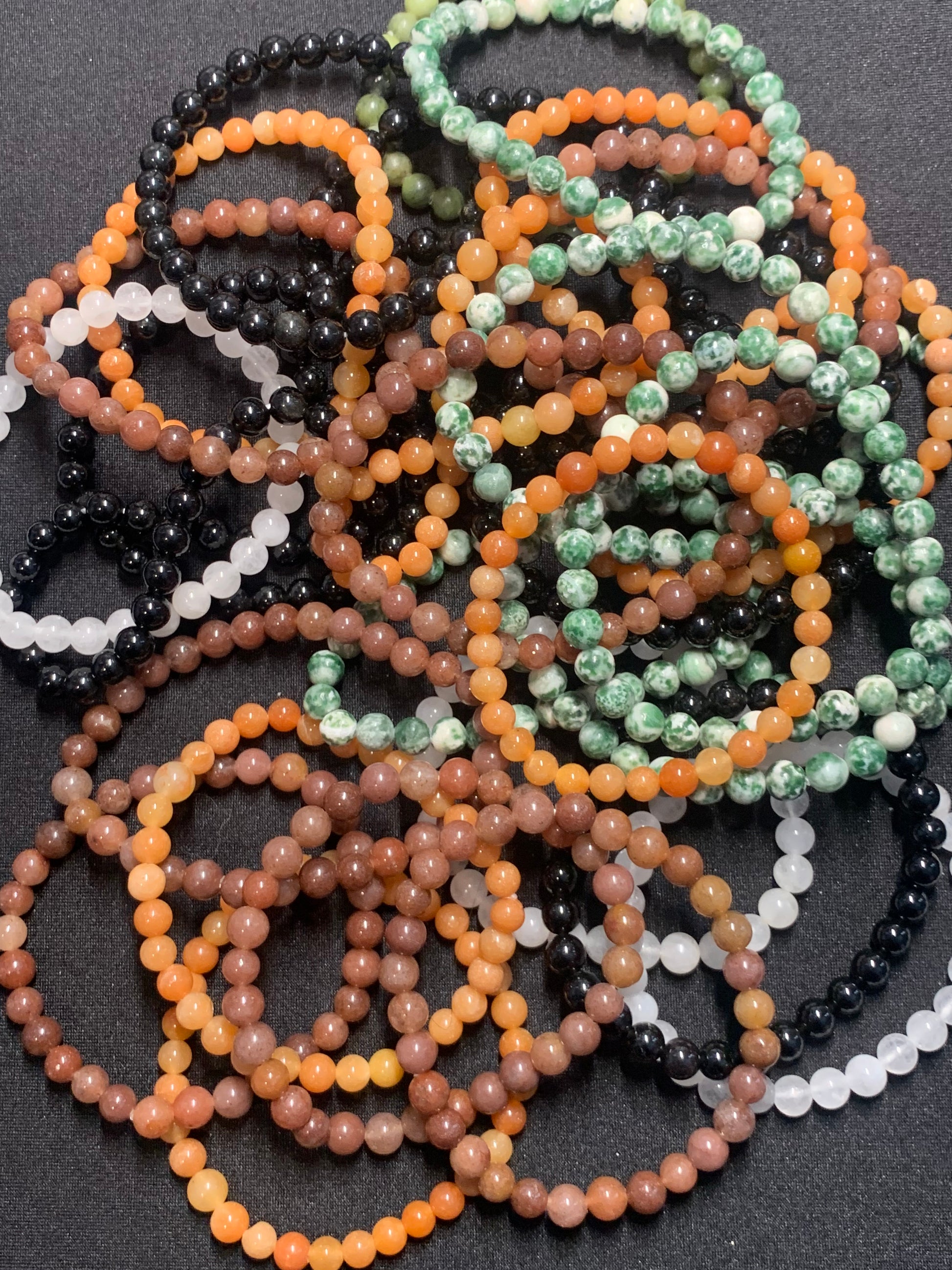 Collection of multicolored beaded bracelets on a dark surface