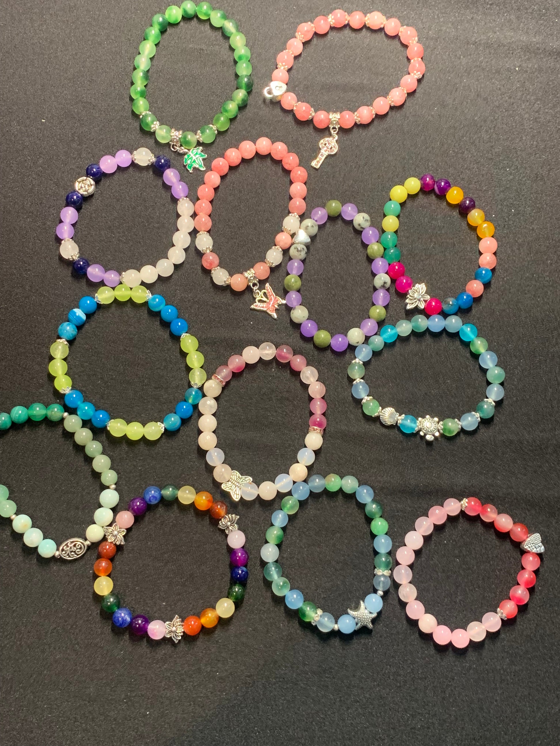 Colorful beaded bracelets on a dark surface