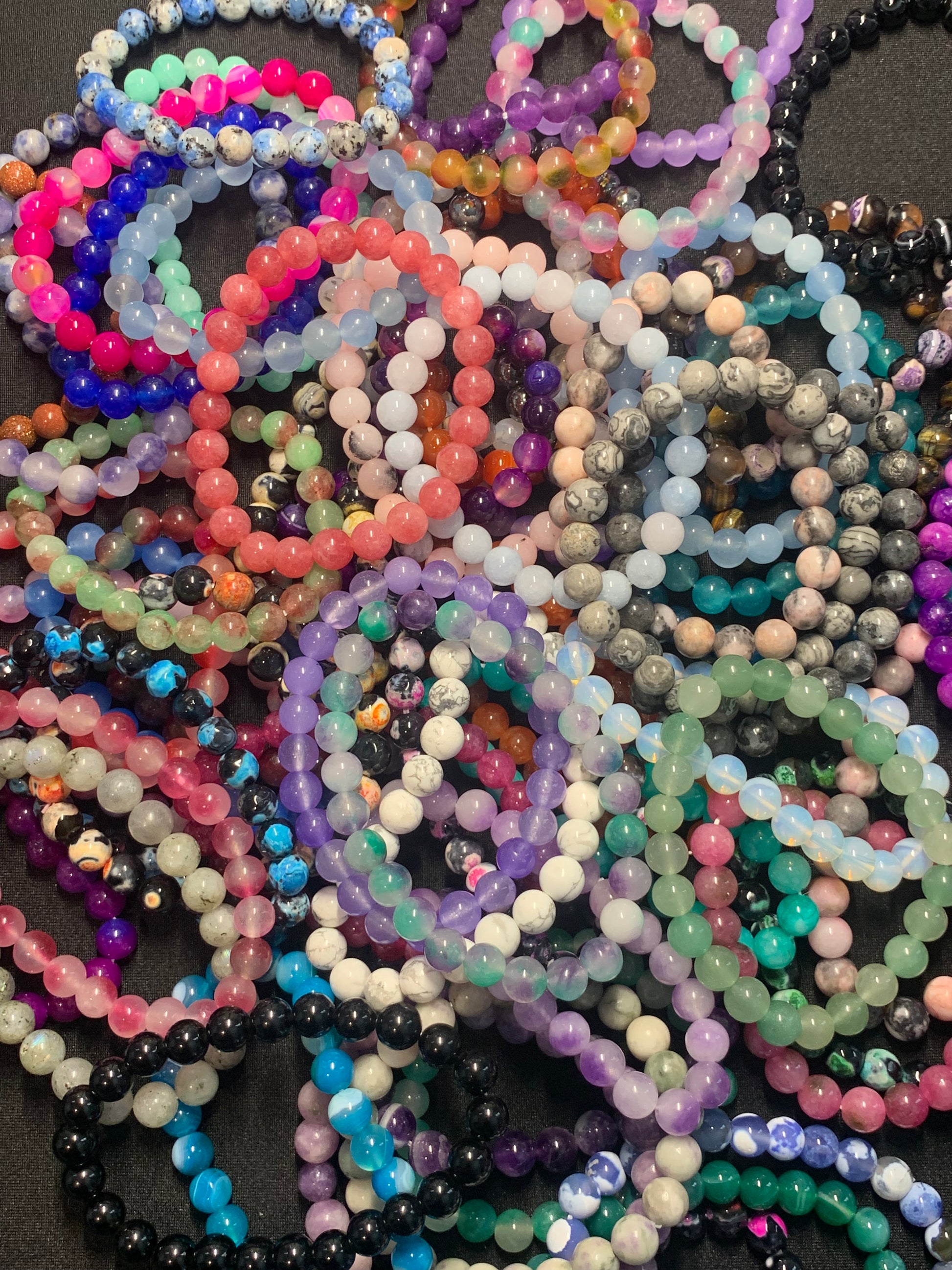 Colorful beaded bracelets on a dark surface