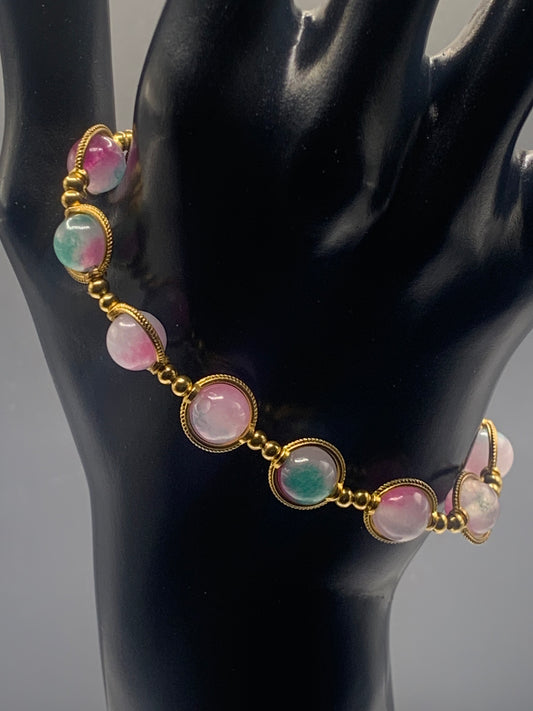 Bracelet with teal and pink chalcedony beads on a black mannequin