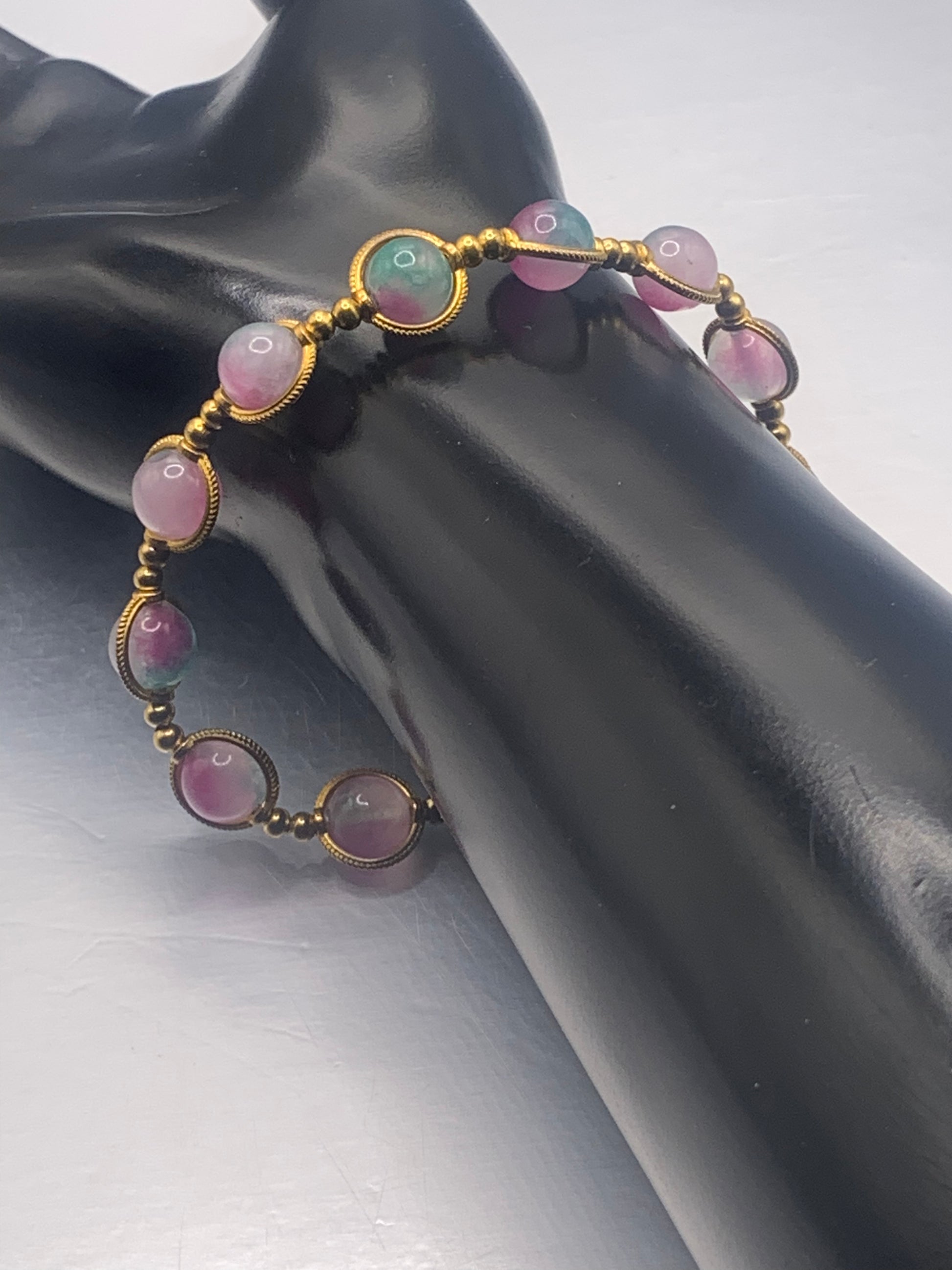 Bracelet with pink and teal chalcedony beads on a black mannequin arm