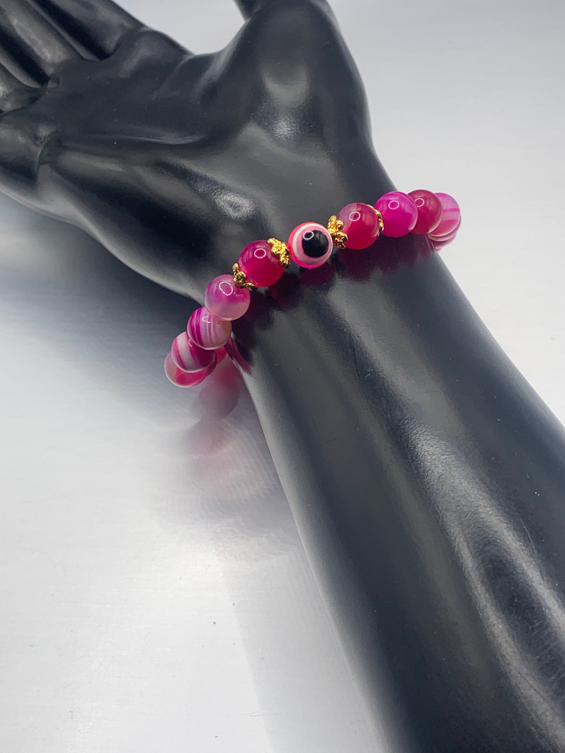 This bracelet features pink lace agate beads and a colorful evil eye resin bead with gold flower caps. These are 8mm beads, made with elastic string to stretch onto the wrist and is approximately 17 cm or 6.7 inches



These are natural semi-precious stones/crystals. Even if they are dyed, the base material is still natural and imperfections are common making them unique