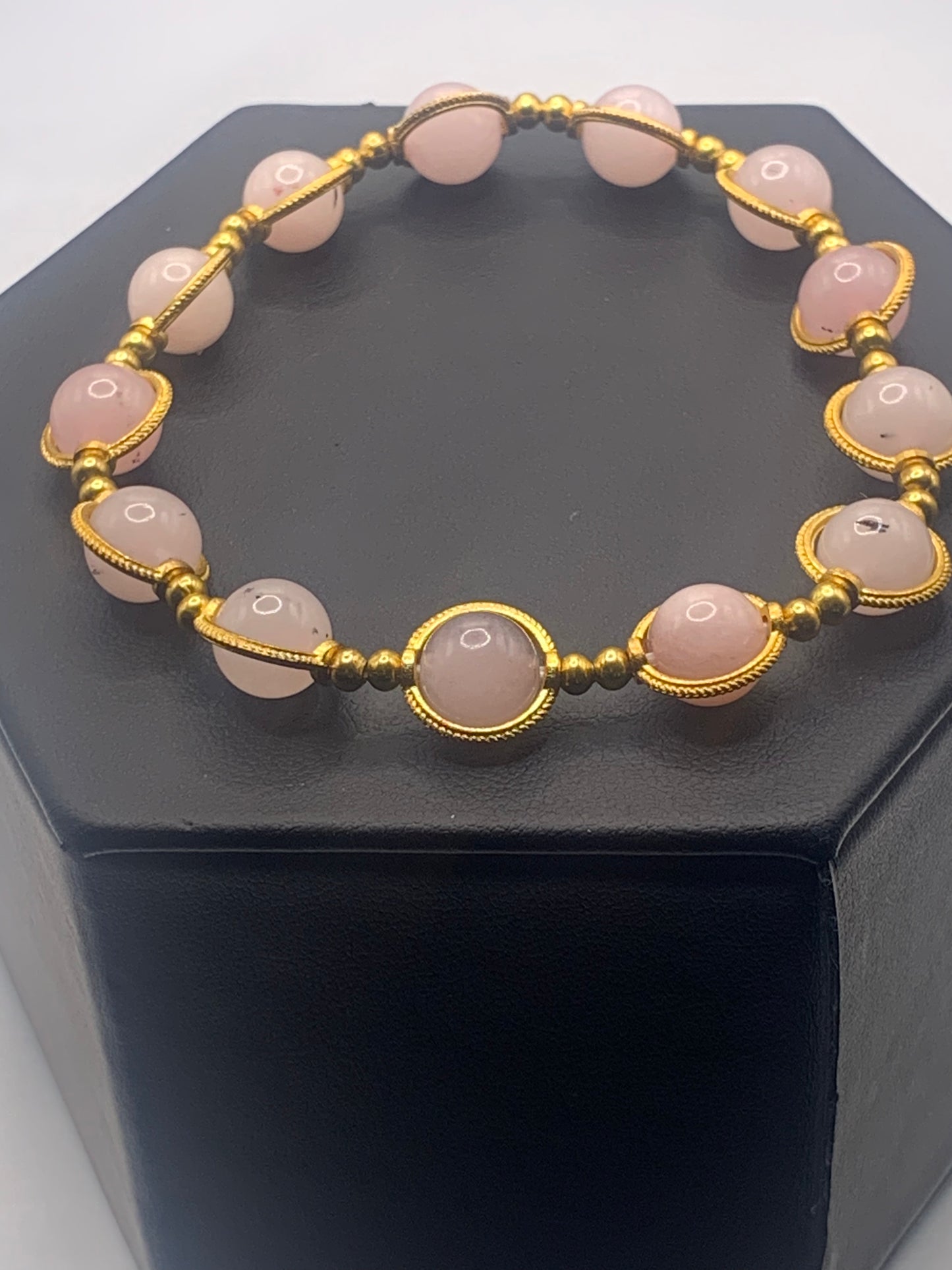 Bracelet with pink opal chalcedony beads and gold accents on a black box