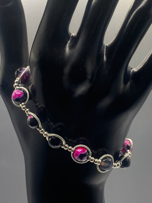 Bracelet with pink orca agate beads and silver accents on a black mannequin hand