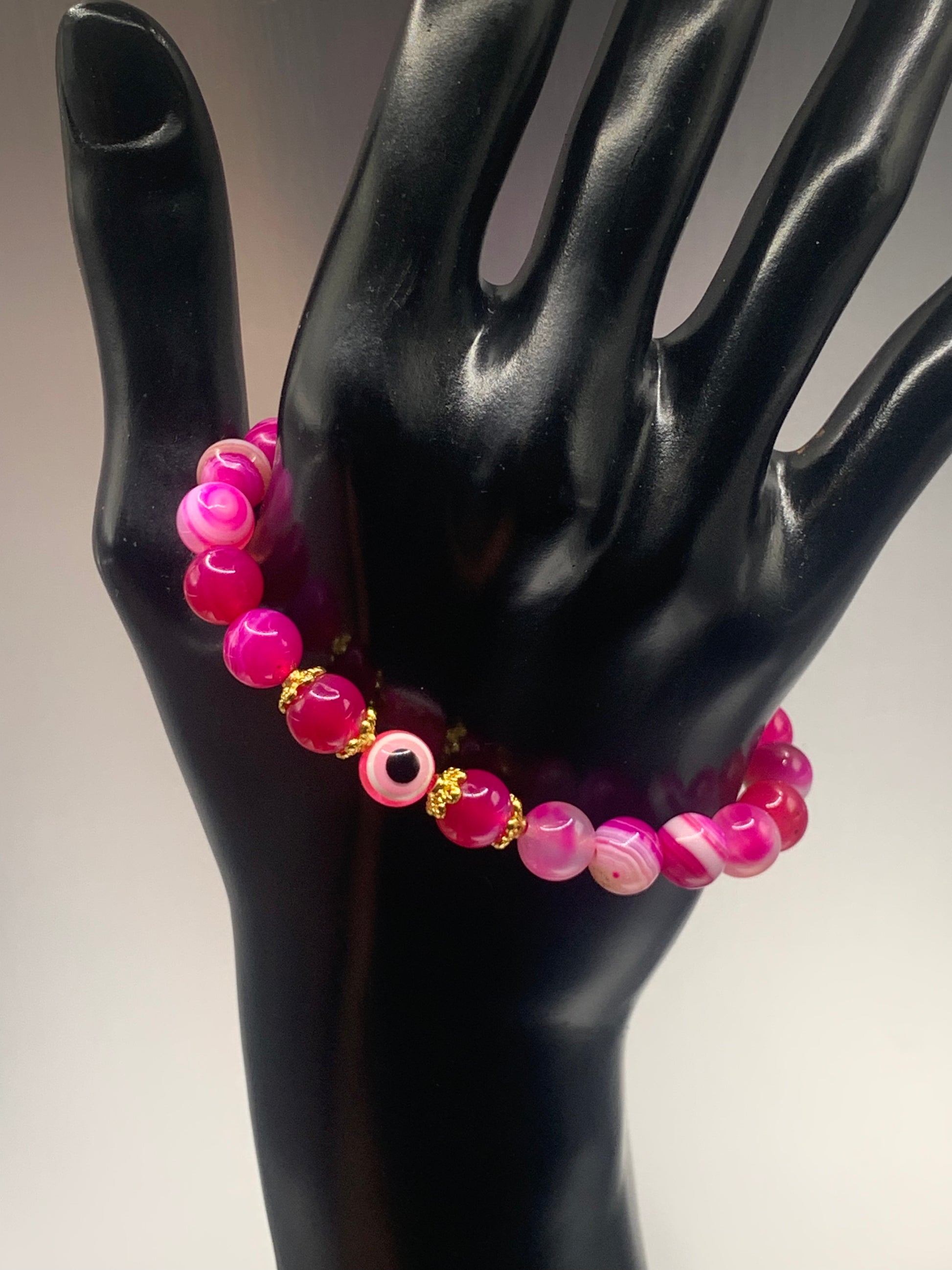 This bracelet features pink lace agate beads and a colorful evil eye resin bead with gold flower caps. These are 8mm beads, made with elastic string to stretch onto the wrist and is approximately 17 cm or 6.7 inches



These are natural semi-precious stones/crystals. Even if they are dyed, the base material is still natural and imperfections are common making them unique