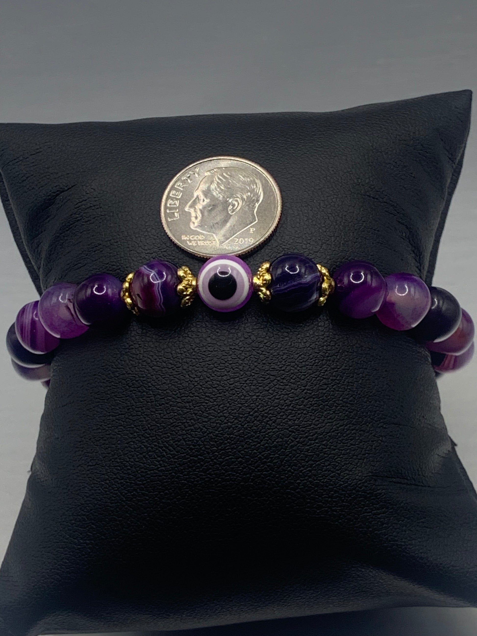 This bracelet features purple lace agate beads and a colorful evil eye resin bead with gold flower caps. These are 8mm beads, made with elastic string to stretch onto the wrist and is approximately 17 cm or 6.7 inches



These are natural semi-precious stones/crystals. Even if they are dyed, the base material is still natural and imperfections are common making them unique