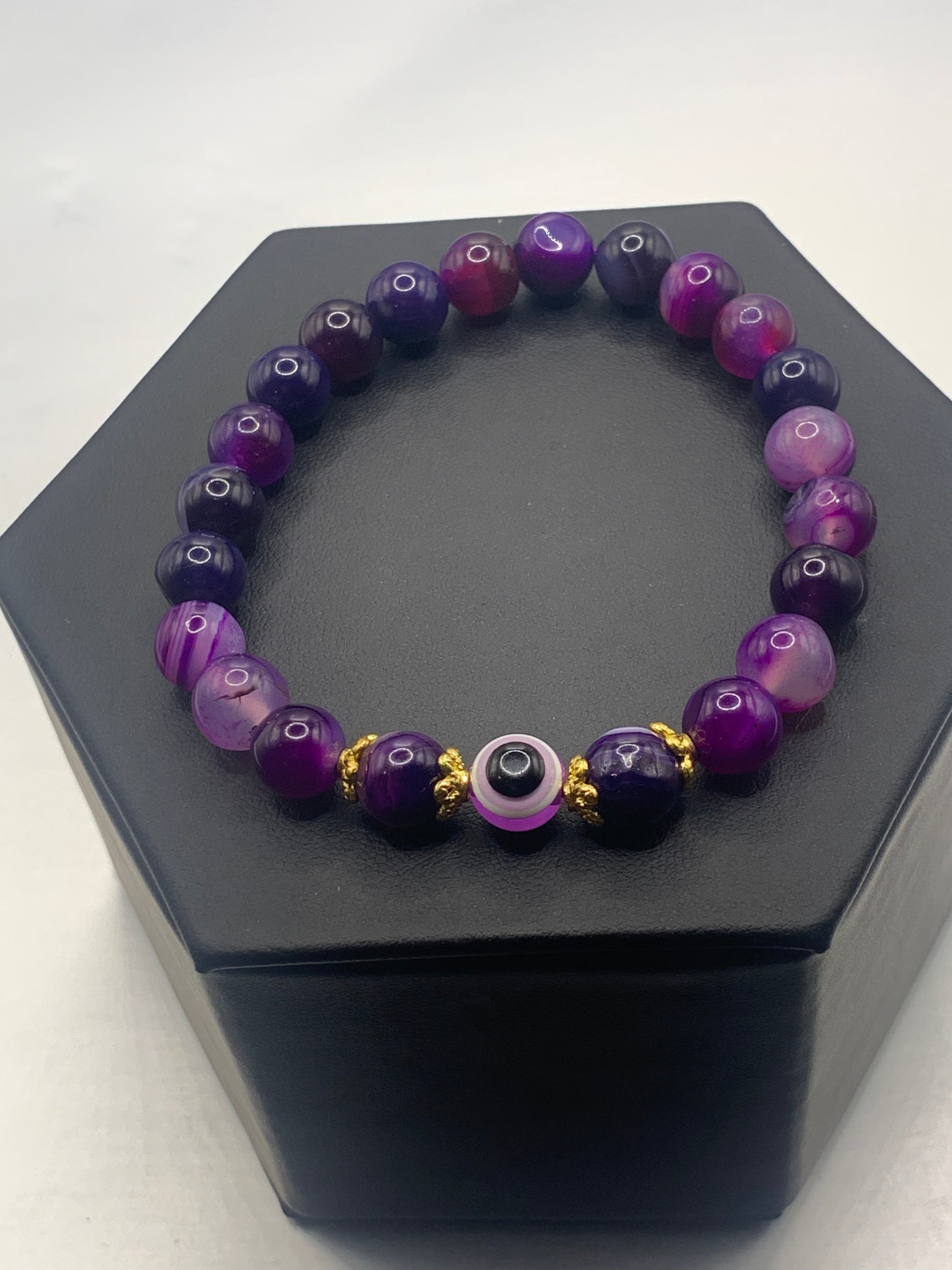 This bracelet features purple lace agate beads and a colorful evil eye resin bead with gold flower caps. These are 8mm beads, made with elastic string to stretch onto the wrist and is approximately 17 cm or 6.7 inches



These are natural semi-precious stones/crystals. Even if they are dyed, the base material is still natural and imperfections are common making them unique