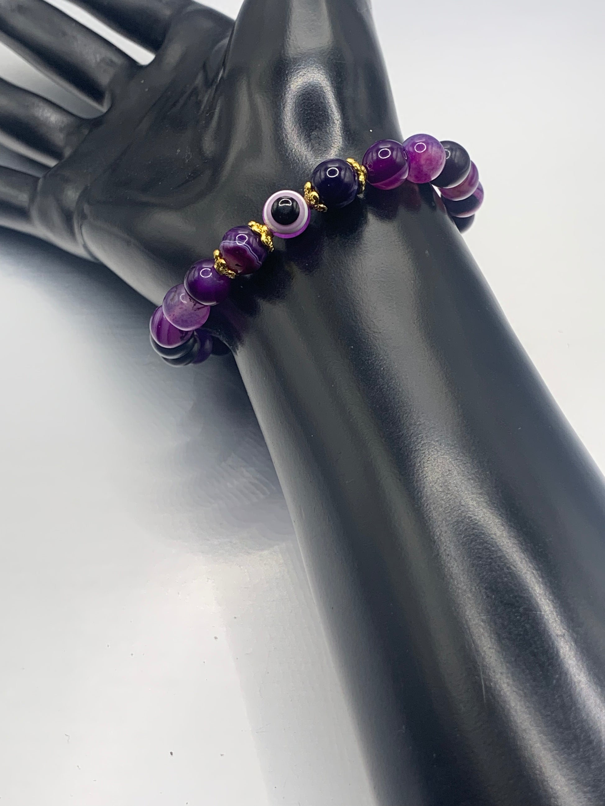 This bracelet features purple lace agate beads and a colorful evil eye resin bead with gold flower caps. These are 8mm beads, made with elastic string to stretch onto the wrist and is approximately 17 cm or 6.7 inches



These are natural semi-precious stones/crystals. Even if they are dyed, the base material is still natural and imperfections are common making them unique