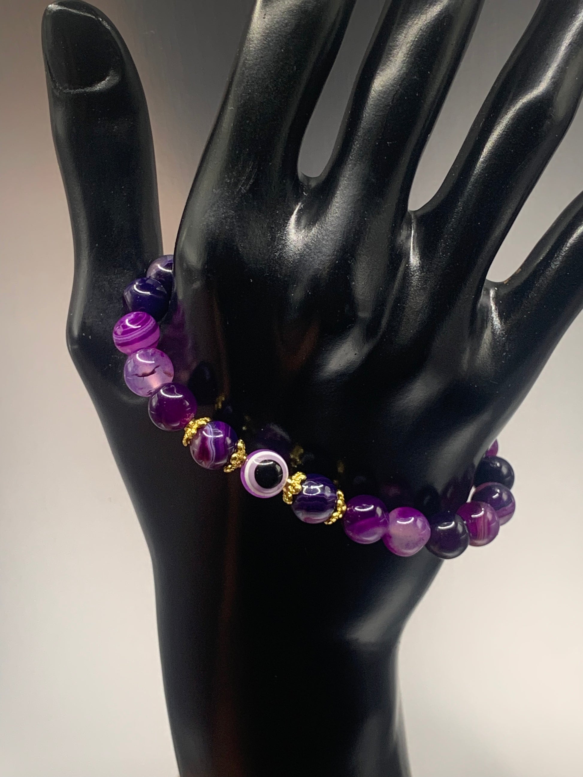 This bracelet features purple lace agate beads and a colorful evil eye resin bead with gold flower caps. These are 8mm beads, made with elastic string to stretch onto the wrist and is approximately 17 cm or 6.7 inches



These are natural semi-precious stones/crystals. Even if they are dyed, the base material is still natural and imperfections are common making them unique